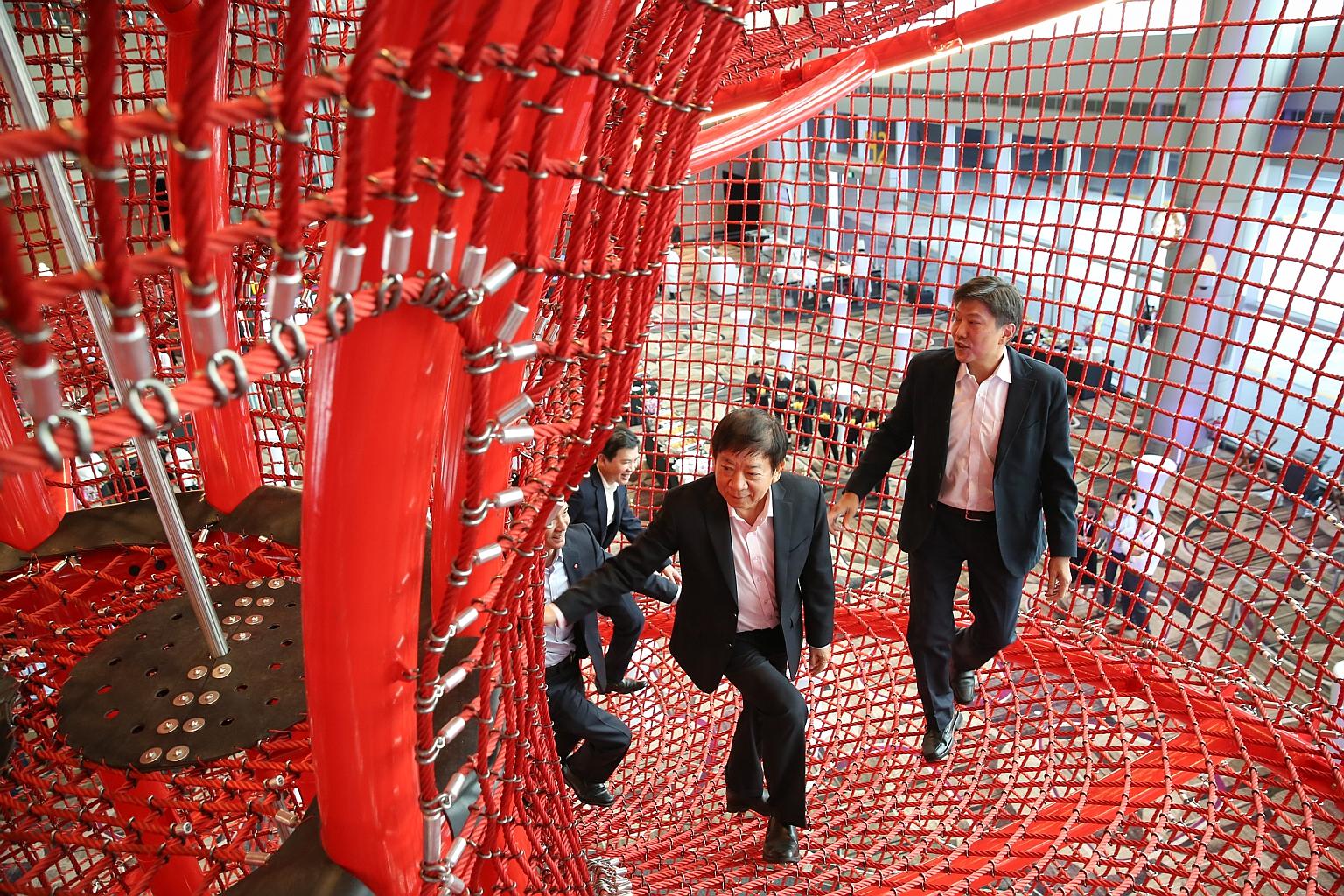 Transport Minister Khaw Boon Wan and Minister in the Prime Minister's Office and labour chief Ng Chee Meng taking a look at the Chandelier, a rope and steel structure at the new playground in Terminal 4.