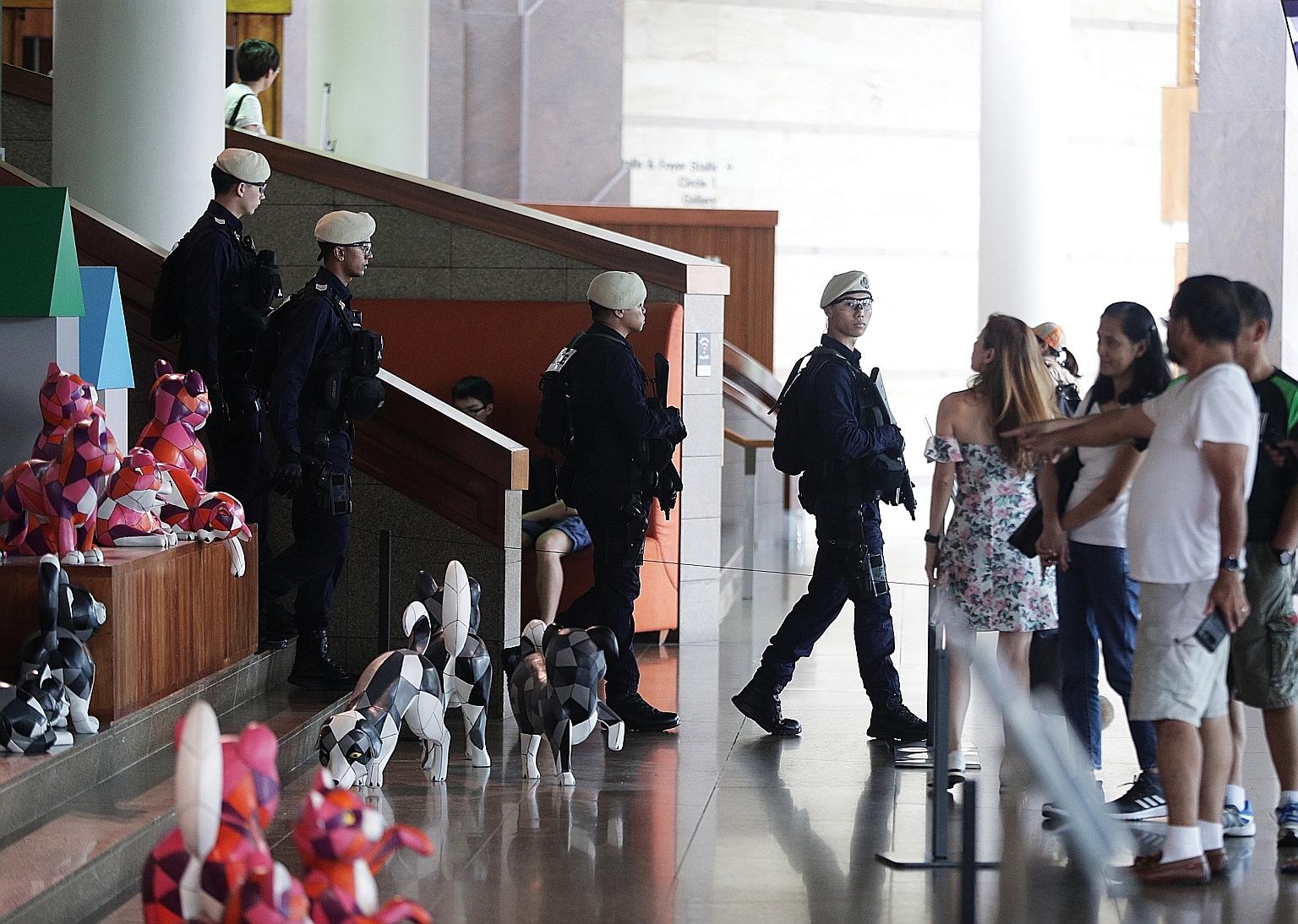 Left: People watching the NDP Preview Show 2 at the Marina Bay Floating Platform yesterday. Above: Members of the In-Situ Response Teams of the Singapore Police Force doing their rounds at the Esplanade. This year, they will make their National Day P