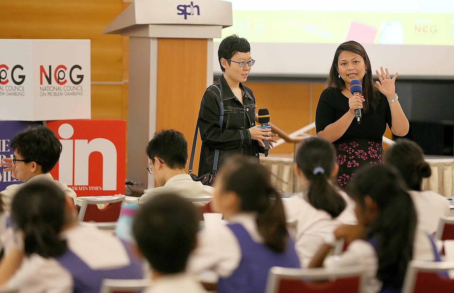 Ms Ang Yiying (left), Straits Times Schools correspondent, and Ms Shahrena Hassan, a senior manager at Singapore Press Holdings (SPH), briefing students participating in the National Youth Media Competition at the SPH auditorium yesterday.