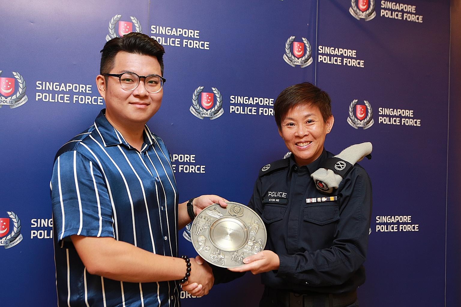 Engineer Goh Tong En receiving his award from Deputy Assistant Commissioner of Police Evon Ng yesterday. He was commended for preventing a man from taking upskirt videos on an escalator at Marsiling MRT station last month.