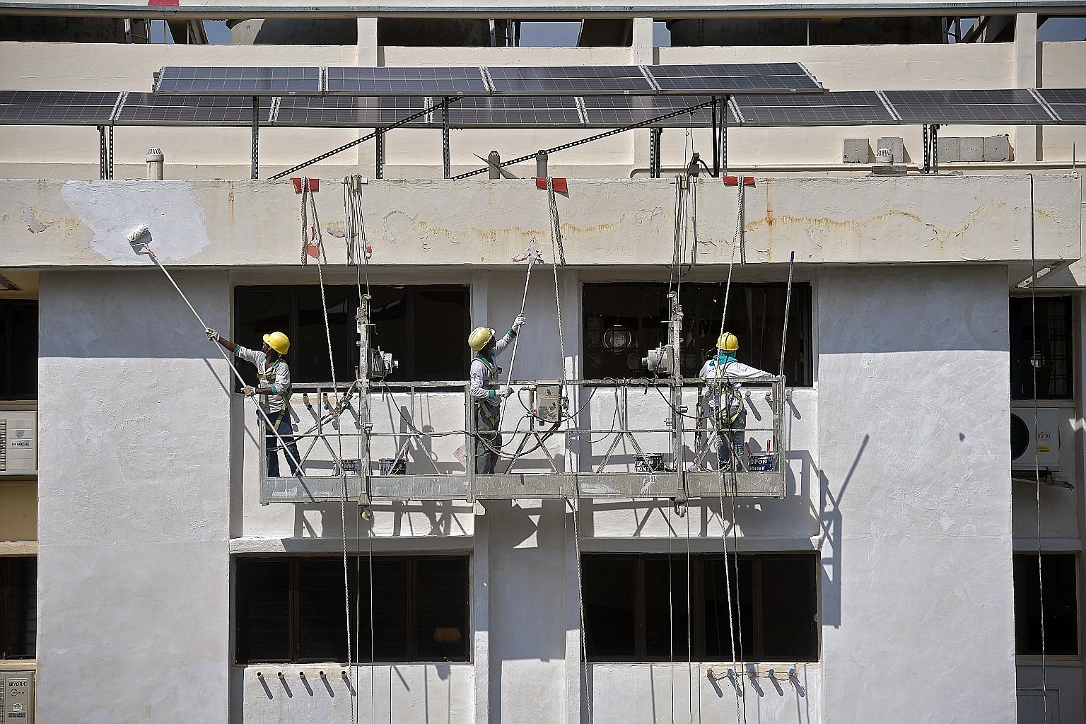 Workers painting the facade of a block of flats in Ang Mo Kio. Prime Minister Lee Hsien Loong said that on a practical note, buildings tend to look worn even before they reach 50 years and that recurrent maintenance costs could be very high.