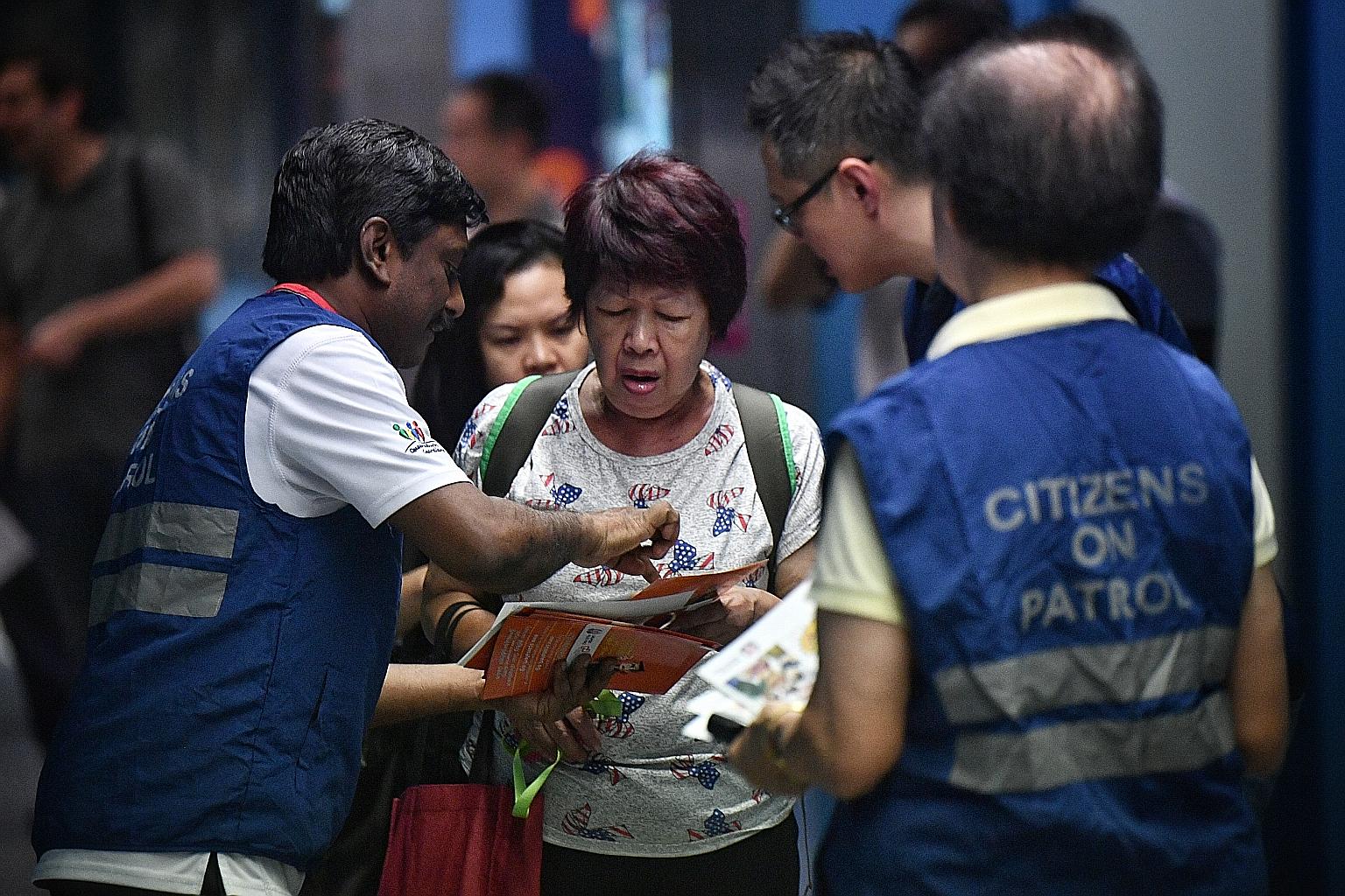 Volunteers from Citizens On Patrol community programme distributing pamphlets on crime prevention at Queenstown MRT station last week. Molestation reports went up by 21.5 per cent. Police said such incidents at public entertainment nightspots and on 