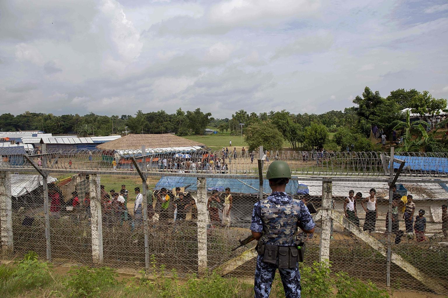 Myanmar border guard police patrolling along the fence in the "no man's land" zone between Myanmar and Bangladesh, as seen from Maungdaw, Rakhine State, during a government-organised visit for journalists yesterday.