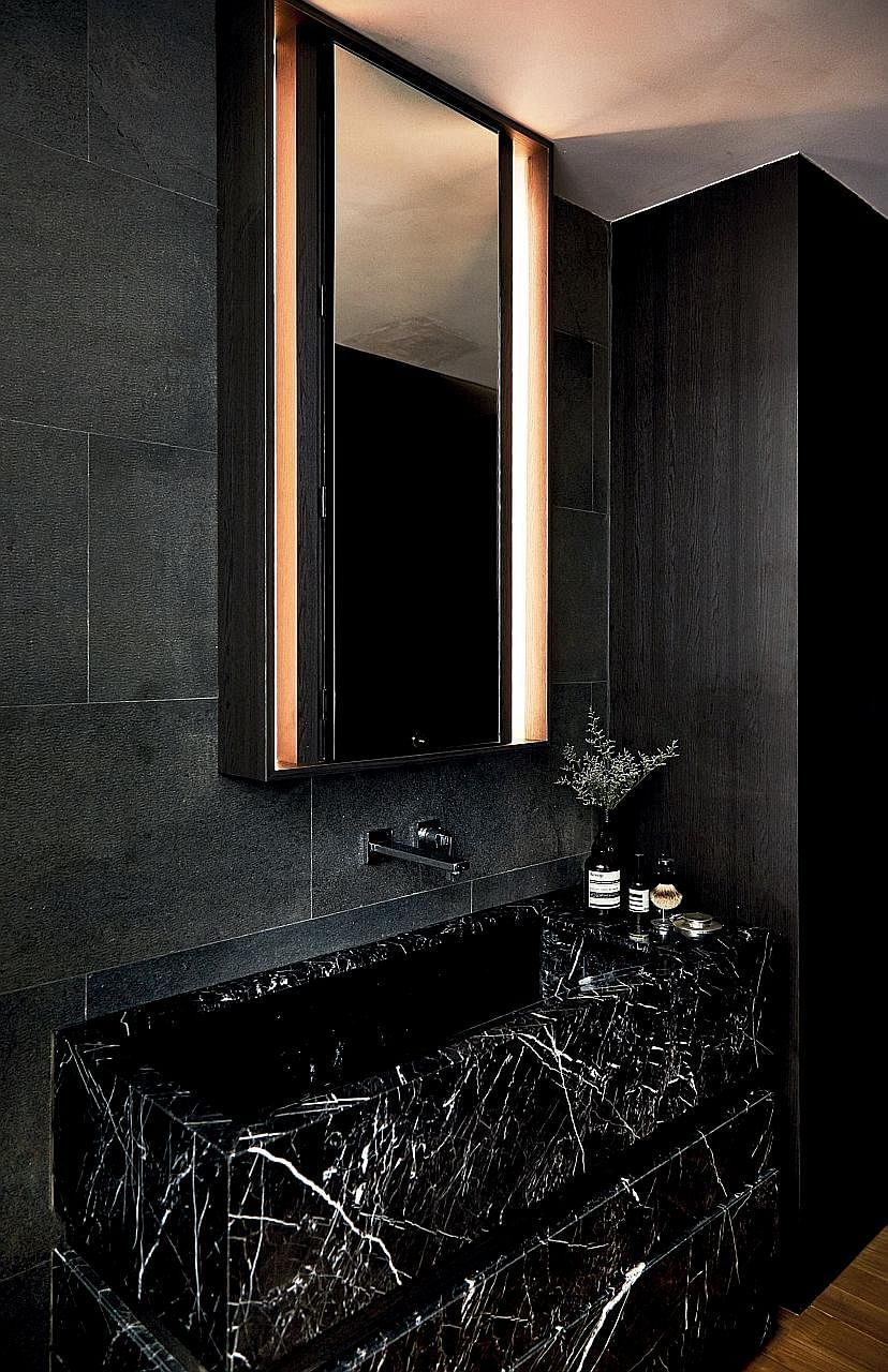The sink, using Nero Marquina marble, was moved outside of the bathroom to create a bigger vanity area. The large island kitchen, holding the sink, dishwasher and wine fridge, occupies a central part of the apartment as the home owners entertain ofte