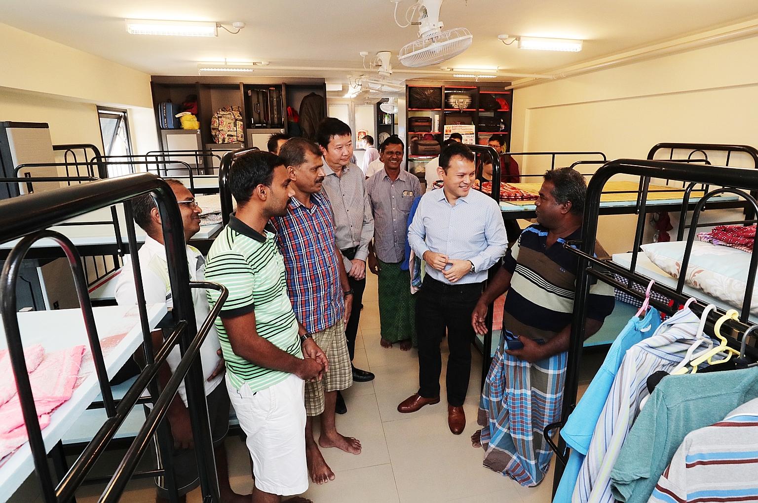Minister of State for Manpower Zaqy Mohamad talking with workers during a visit to a dorm in Greyform Building. Mr Zaqy said enforcement efforts have been tightened with the use of analytics.