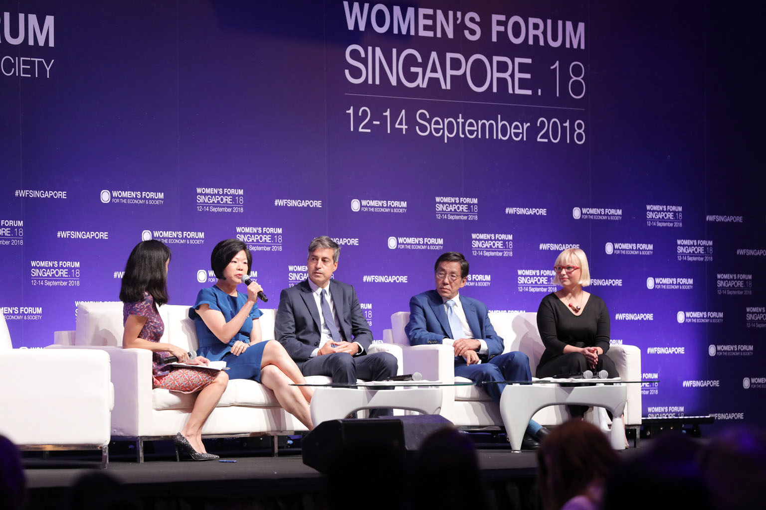 Ms Sim Ann, Senior Minister of State for Communications and Information, and Culture, Community and Youth (holding microphone) speaking at a plenary session at the Women's Forum Singapore yesterday. The three-day forum has lined up more than 20 sessi