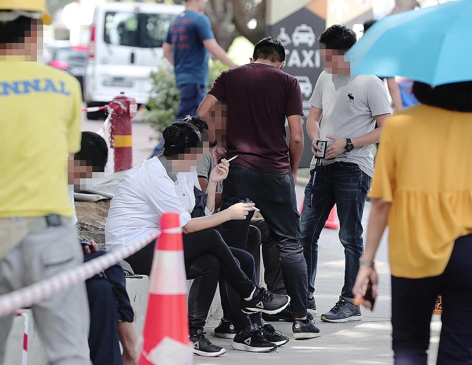 Singapore Customs officers checking whether people were smoking duty-unpaid cigarettes in Tampines Central. Offenders caught in the three-day operation were issued composition sums ranging from $500 to $1,200.