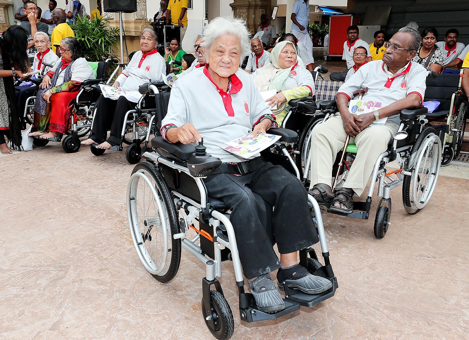 Madam Tan Beng Kee, 76, trying out a motorised wheelchair yesterday. Seven seniors each received a gift of a motorised wheelchair at a charity event, at the Sri Thendayuthapani Temple, organised by the Chettiars' Temple Society. The society also dona