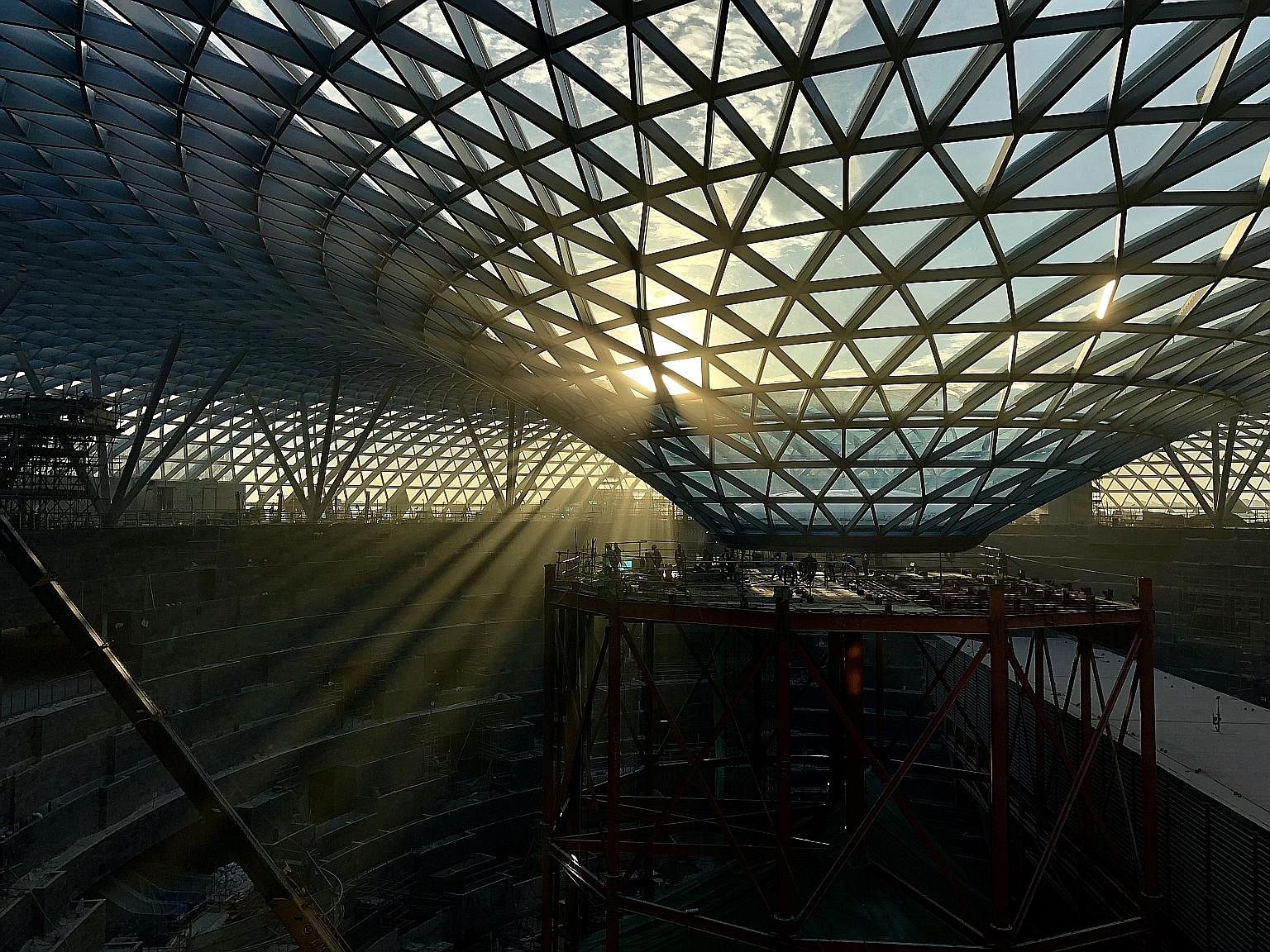 Above: Visitors using a travelator at an open area of Jewel Changi Airport. Left: A skylight architectural feature at the upcoming development, which will also showcase a 40m-high indoor waterfall and a five-storey garden.