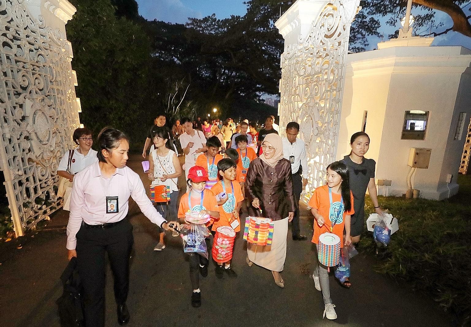 President Halimah Yacob leading children on a tour of the Istana grounds after a Mid-Autumn Festival picnic yesterday. The children were President's Challenge beneficiaries from Care Community Services Society, Focus on the Family, Daughters of Tomor