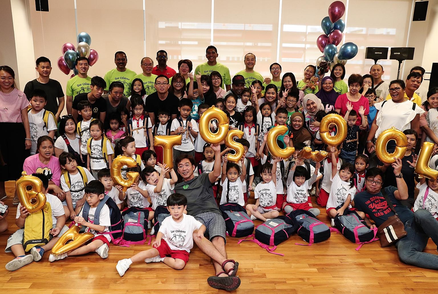 Ang Mo Kio GRC MP Darryl David (back row, centre, in green T-shirt) with grassroots volunteers, donors, parents and the kindergarten children entering Primary 1 next year. The children received school bags with new uniforms, shoes and socks for Ci Yu
