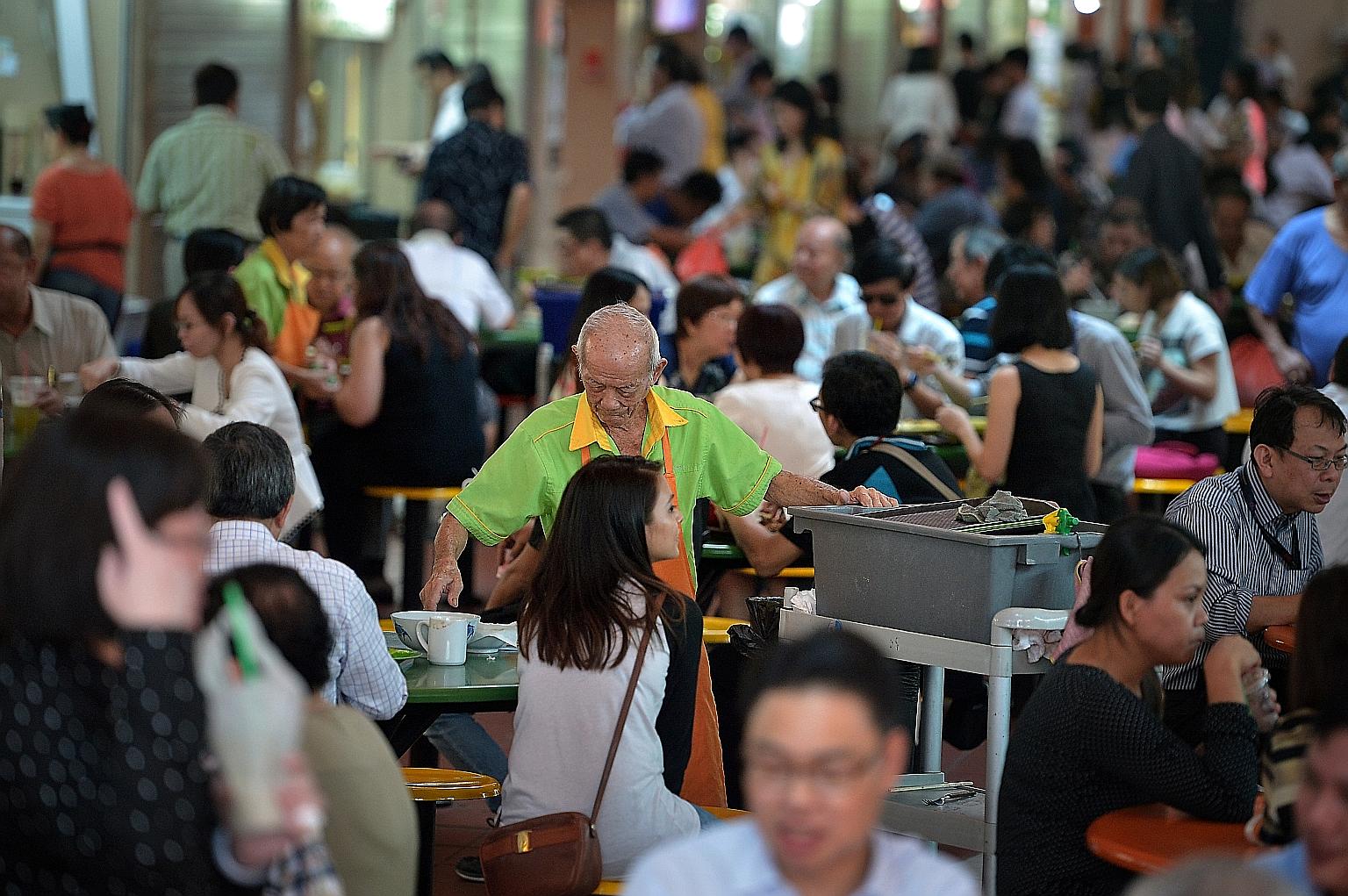 Cleaners at the Maxwell Food Centre. Under the new law, over 40,000 Singaporean and permanent resident cleaners may receive up to 4 per cent more in wages each year.
