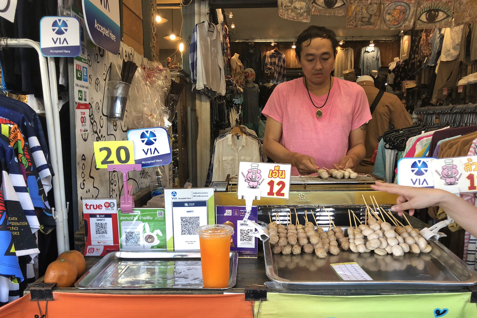Mr Saroj Cheewasittikron, who sells orange juice and meatballs at Chatuchak market, is a participating merchant in Singtel's cross-border digital payment network VIA.
