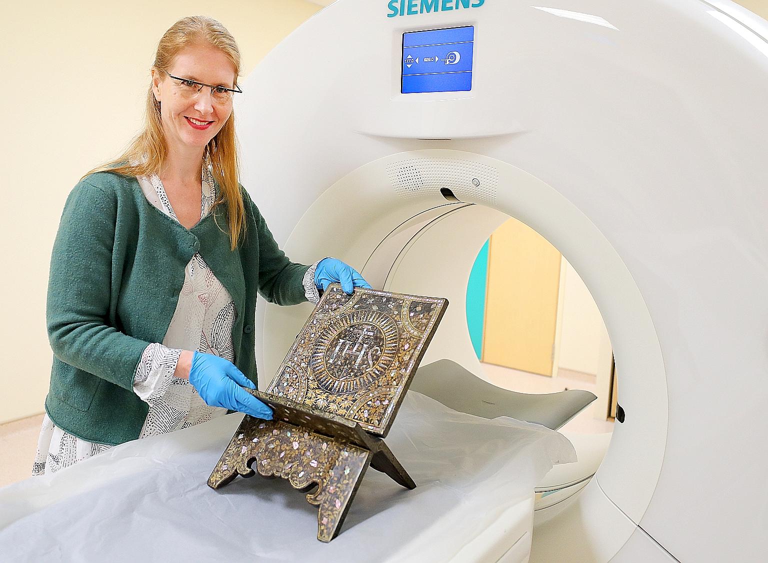 Ms Birte Koehler, a senior object conservator at the Heritage Conservation Centre, with a centuries-old wooden book stand that underwent a CT scan at the Singapore General Hospital yesterday.