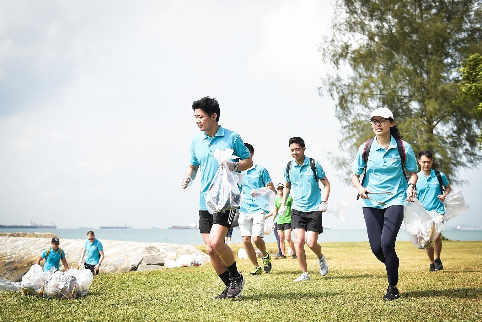 Mr Lee Leong Hui (in front) plogging at the East Coast beach with his colleagues from property firm Lendlease last Thursday, as part of the company's annual community day. The term "plogging" is a mash-up of the word "jogging" and the Swedish words "