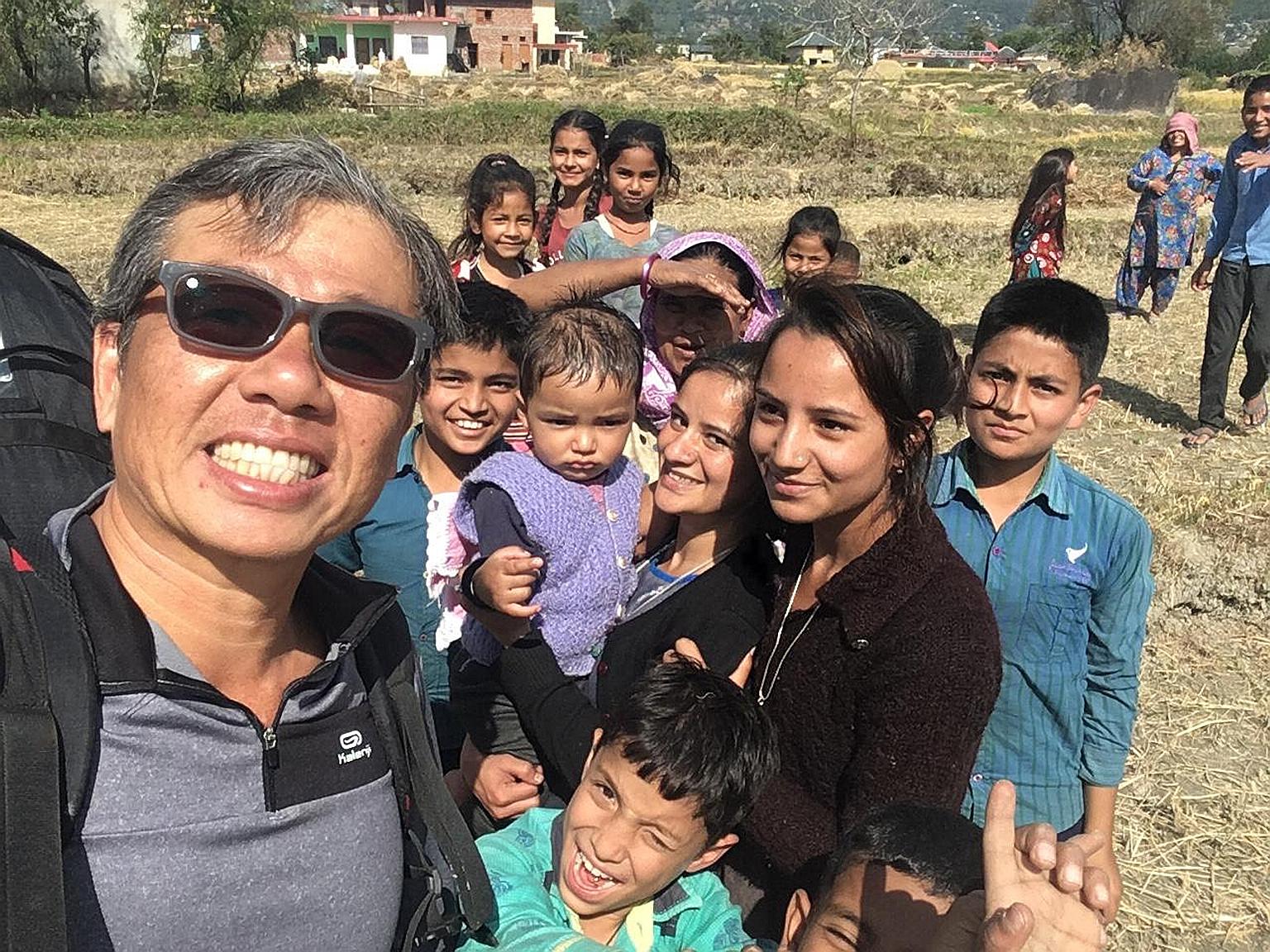 Mr Ng Kok Choong with local children in Bir Billing, India, last week after completing a flight. The day before he went missing, Mr Ng had cautioned other paragliders to be careful because of the treacherous weather conditions.