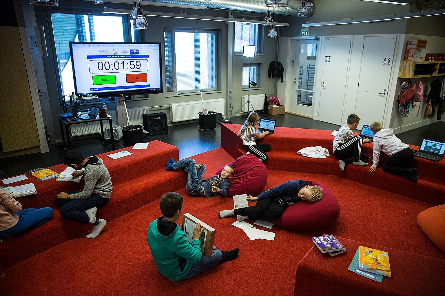 Students from Kalasatama Comprehensive School having a mathematics lesson. Teachers say the open layout and desk-less learning, which more schools in Finland are adopting, help children - both mainstream and special needs - enjoy learning and focus b