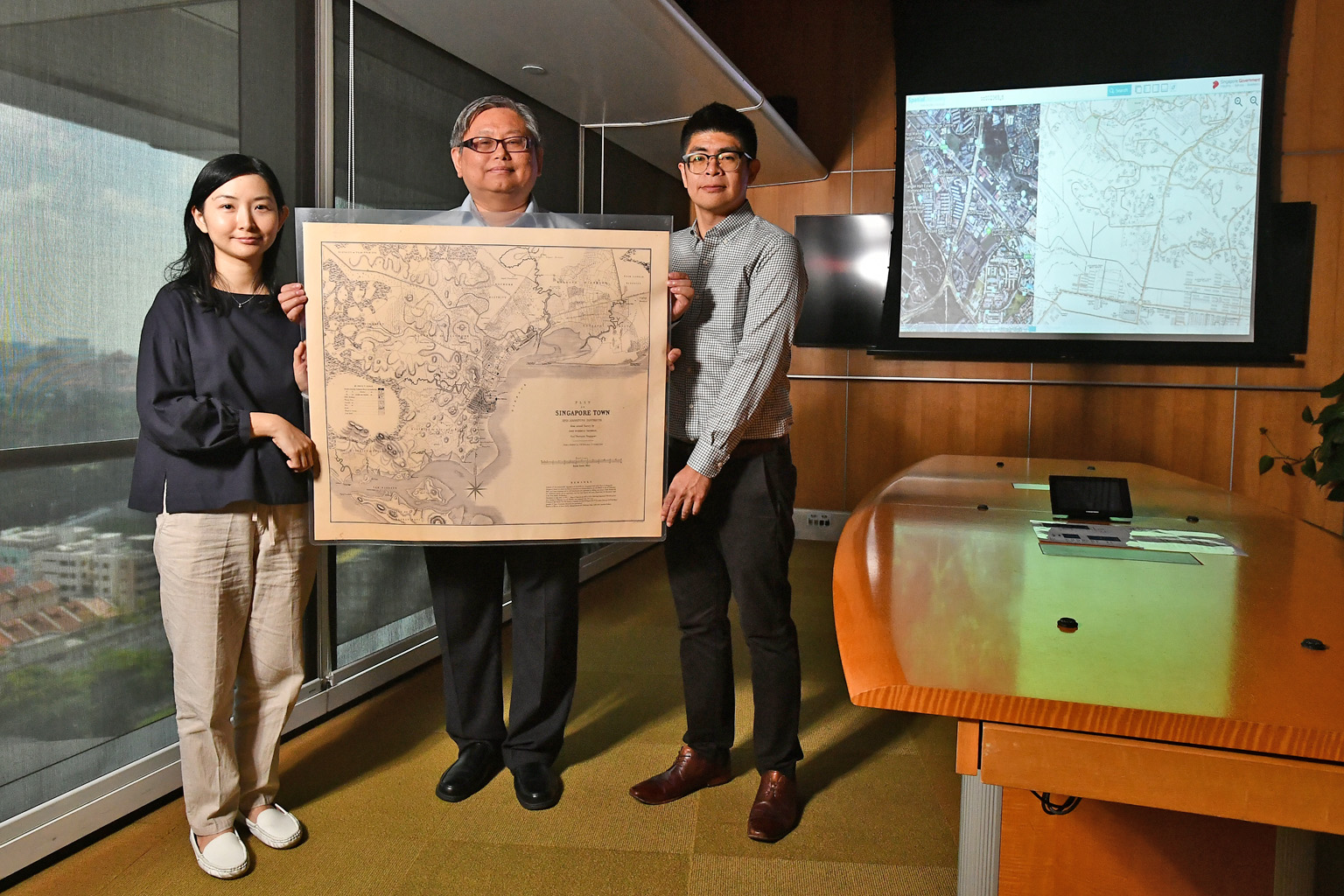 Mr Yit Chin Chuan, 51, NAS' assistant director, archives services; flanked by Ms Loh Yuexia, 36, an assistant archivist; and Mr Patrick Cher, 32, a project manager; with the 1846 plan of Singapore produced by government surveyor, architect and engine