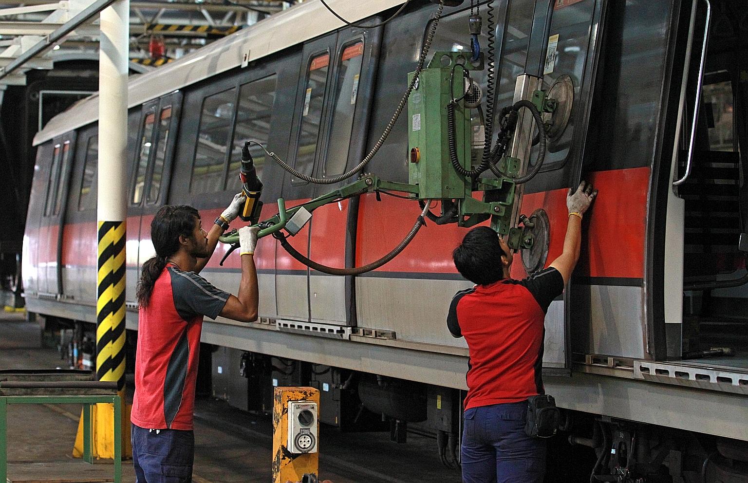 Employees carrying out maintenance works at Bishan Depot. There are currently about a dozen different types of trains plying the MRT network run by the two operators here.
