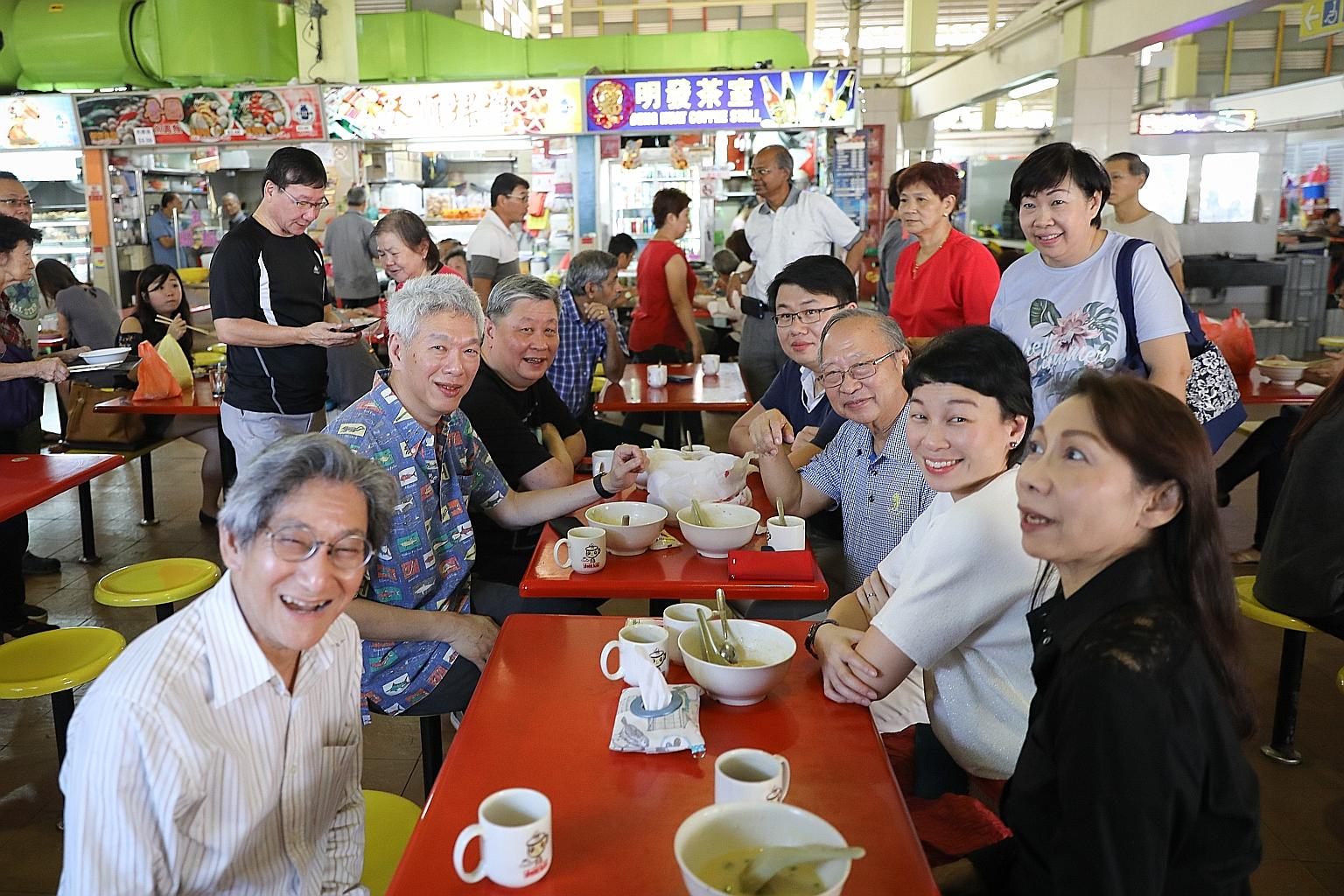 Dr Tan Cheng Bock (seated third from bottom right) and Mr Lee Hsien Yang (second from bottom left) having breakfast at West Coast Market and Food Centre yesterday.