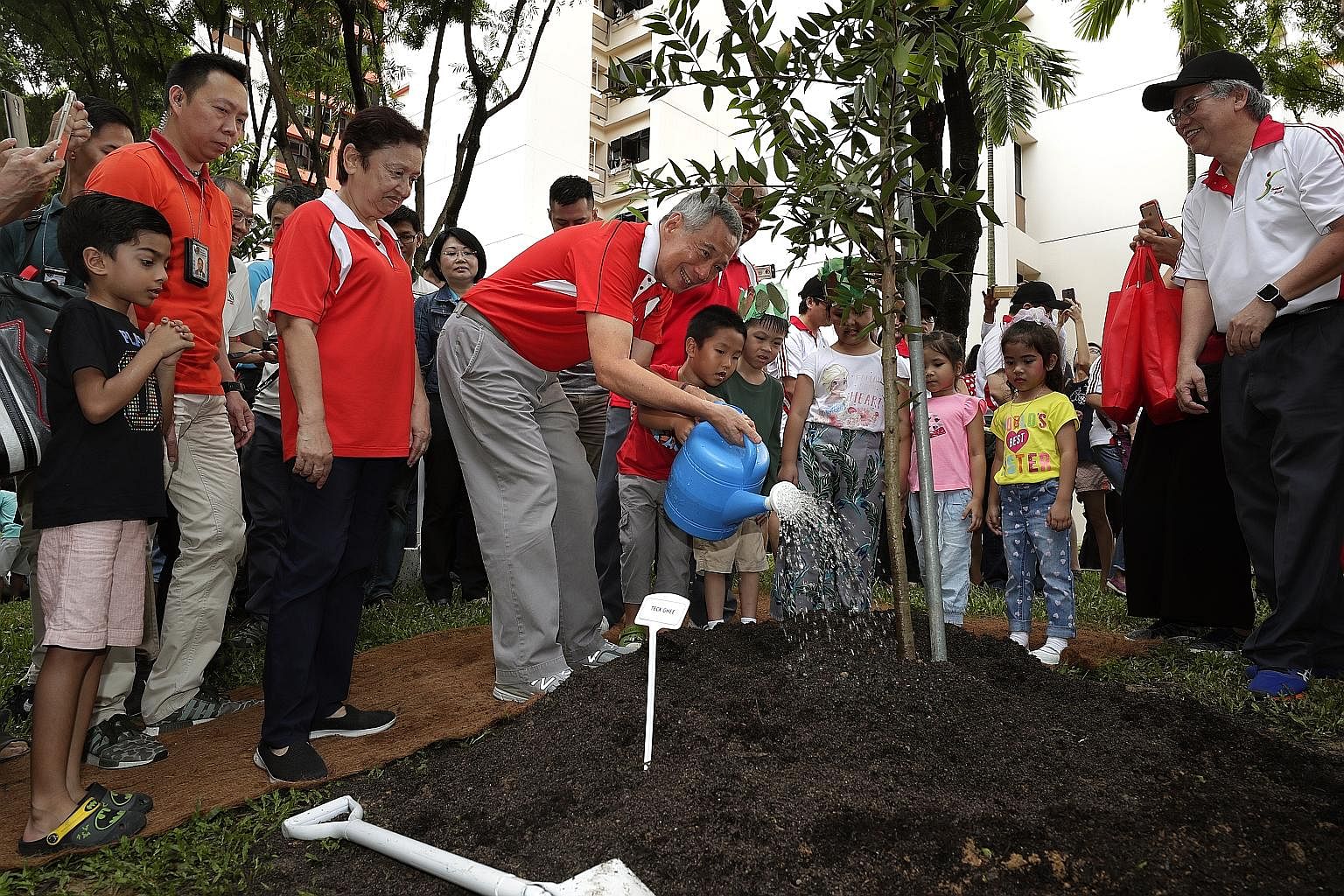 Prime Minister Lee Hsien Loong watering a tree he planted in front of Block 405A Fernvale Lane in Sengkang at an annual tree-planting event yesterday. 	He and his fellow Ang Mo Kio GRC MPs - Dr Koh Poh Koon, Mr Ang Hin Kee and Mr Gan Thiam Poh - as w