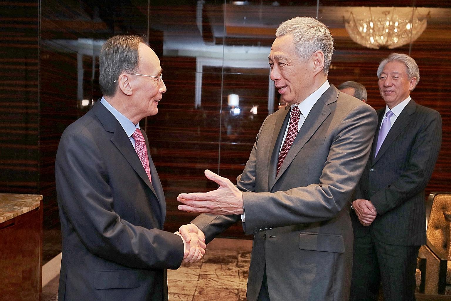 Prime Minister Lee Hsien Loong, accompanied by Deputy Prime Minister Teo Chee Hean, greeting visiting Chinese Vice-President Wang Qishan at The St Regis Singapore before hosting a lunch for him yesterday afternoon. PM Lee and Mr Wang discussed the br