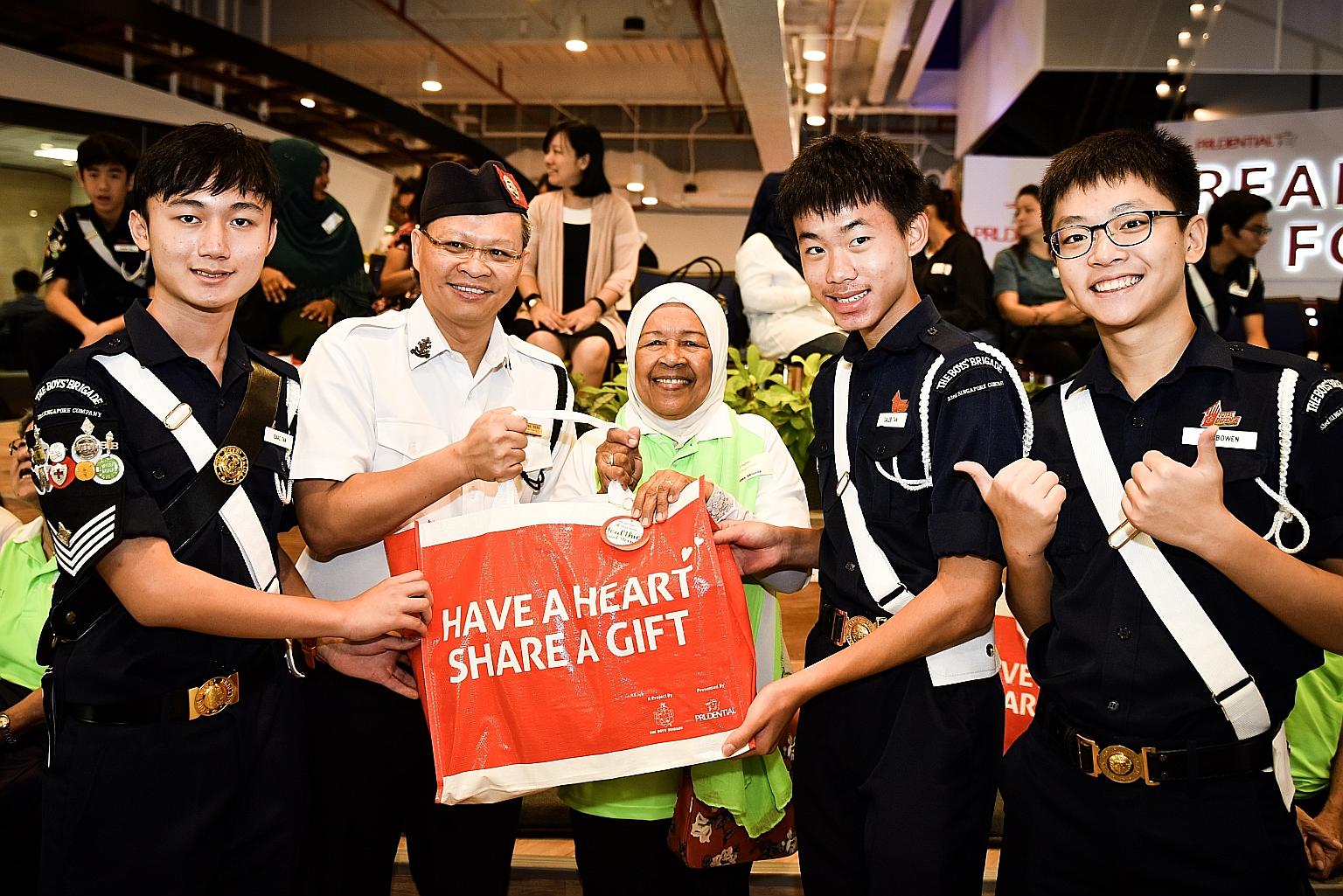 Boys' Brigade members (from left) Isaac Tan, Caleb Tan and Too Bowen, all 15, with Mr Poh Leong Berg, president of The Boy's Brigade Singapore, and Madam Habibi Rosdi.