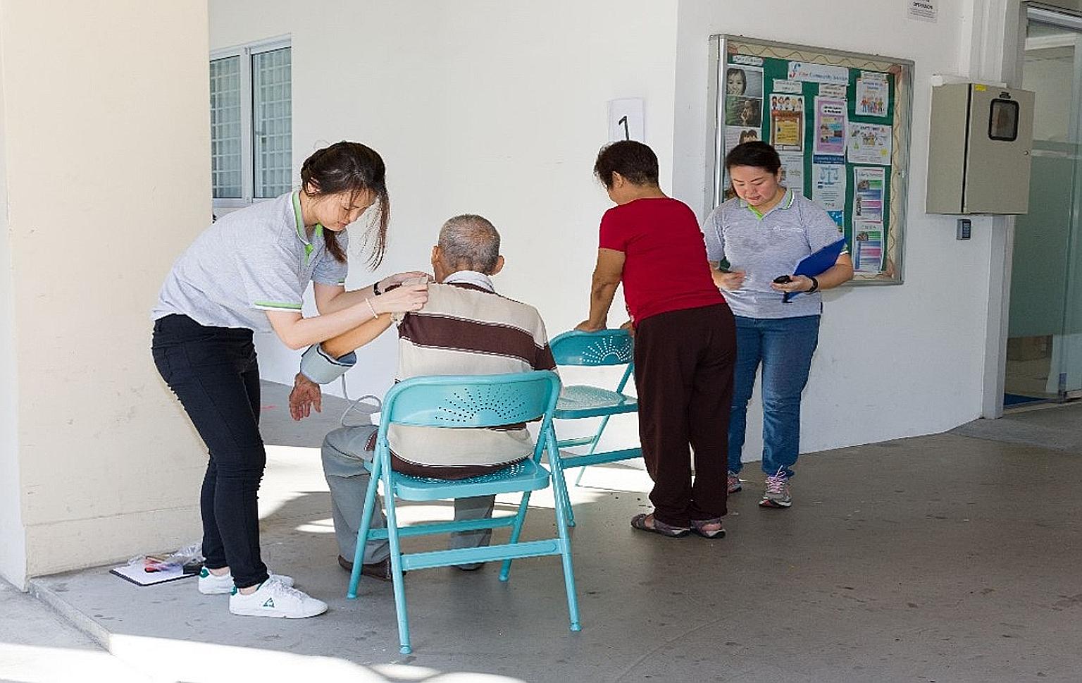 Staff from the Geriatric Education and Research Institute conduct blood pressure checks prior to carrying out a simple exercise session for older adults.