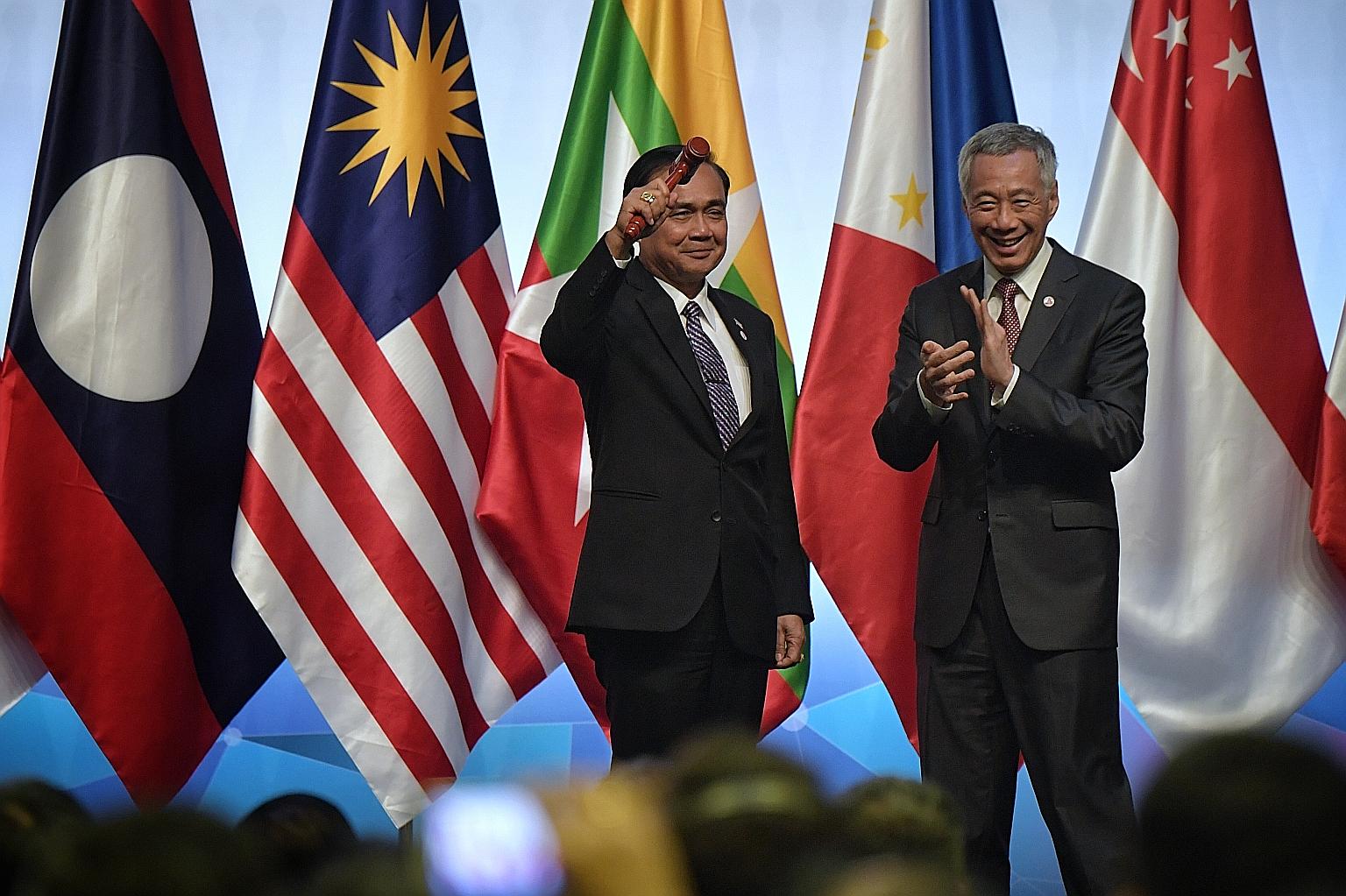 Thailand's Prime Minister Prayut Chan-o-cha holding the chairman's symbolic gavel after receiving it from Prime Minister Lee Hsien Loong at the closing ceremony of the 33rd Asean Summit yesterday. Thailand takes over the chairmanship of Asean from Si
