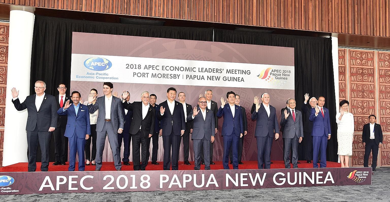 Prime Minister Lee Hsien Loong listening to a presentation at the Apec summit in Port Moresby yesterday. He called on fellow leaders to press on with efforts to form a Free Trade Area of the Asia-Pacific.