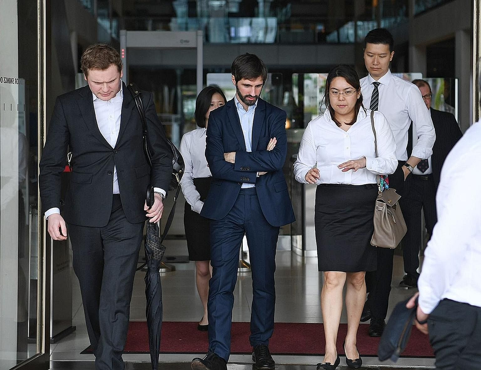 B2C2 co-founder Maxime Boonen (centre), with his lawyers at the court yesterday. The electronic market maker is suing cryptocurrency exchange operator Quoine over a "unilateral reversal" of orders on its platform.