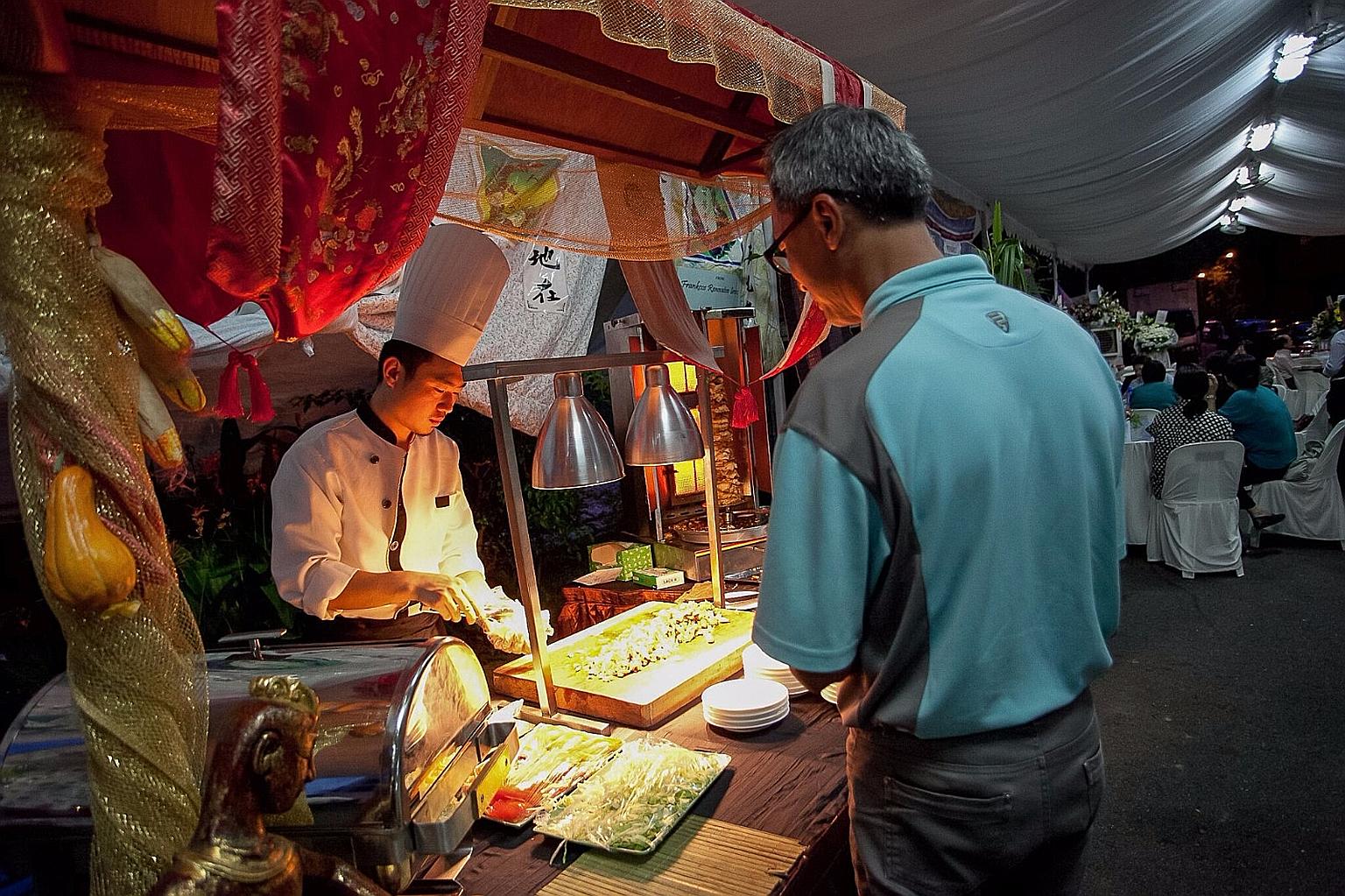 Madam Lim Geok Khim, with her sons (from left) Cleon, 22, Clevon, 18, and daughter Cloey, 16, on a family trip to Europe. A stall serving chicken kebabs at a wake, held outside a private residence in Bukit Timah, earlier this year.