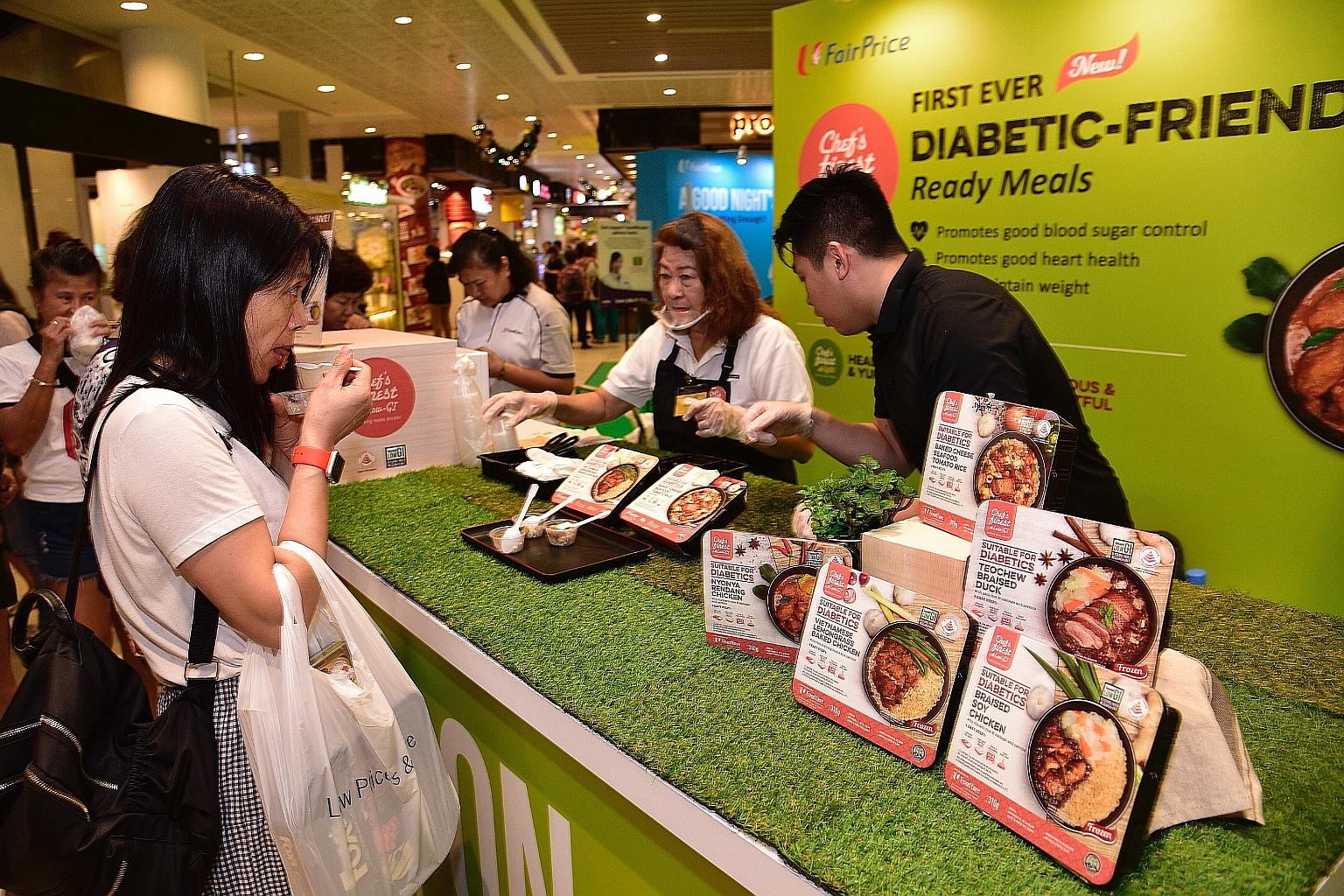 Shoppers tasting the new low-GI ready-to-eat meals at the FairPrice Xtra outlet at AMK Hub yesterday.