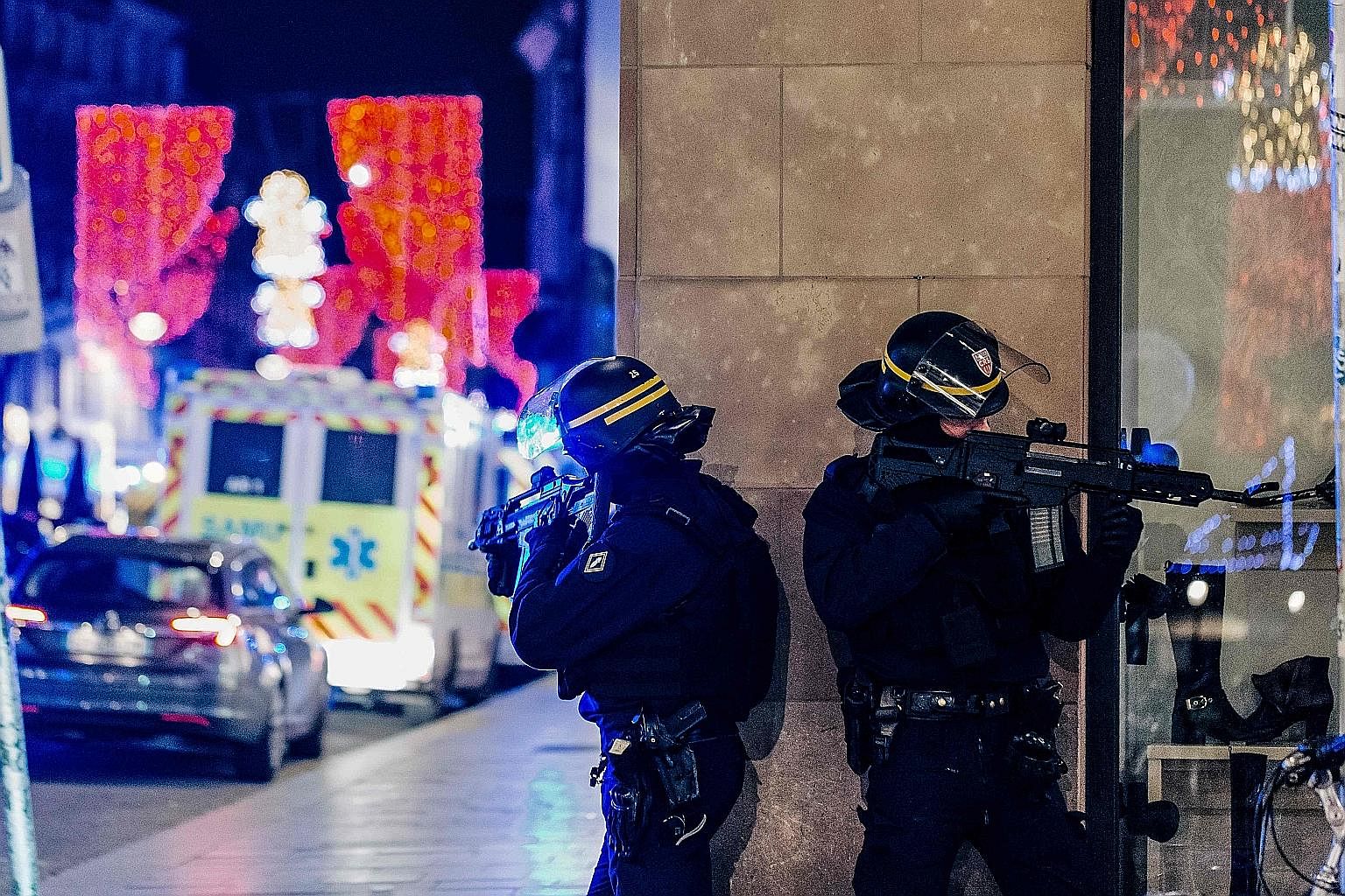 Police officers standing guard near the scene of a shooting on Tuesday in Strasbourg, eastern France, where a manhunt was launched for a gunman who killed at least two people near the city's famed Christmas market. Police identified the suspect as re