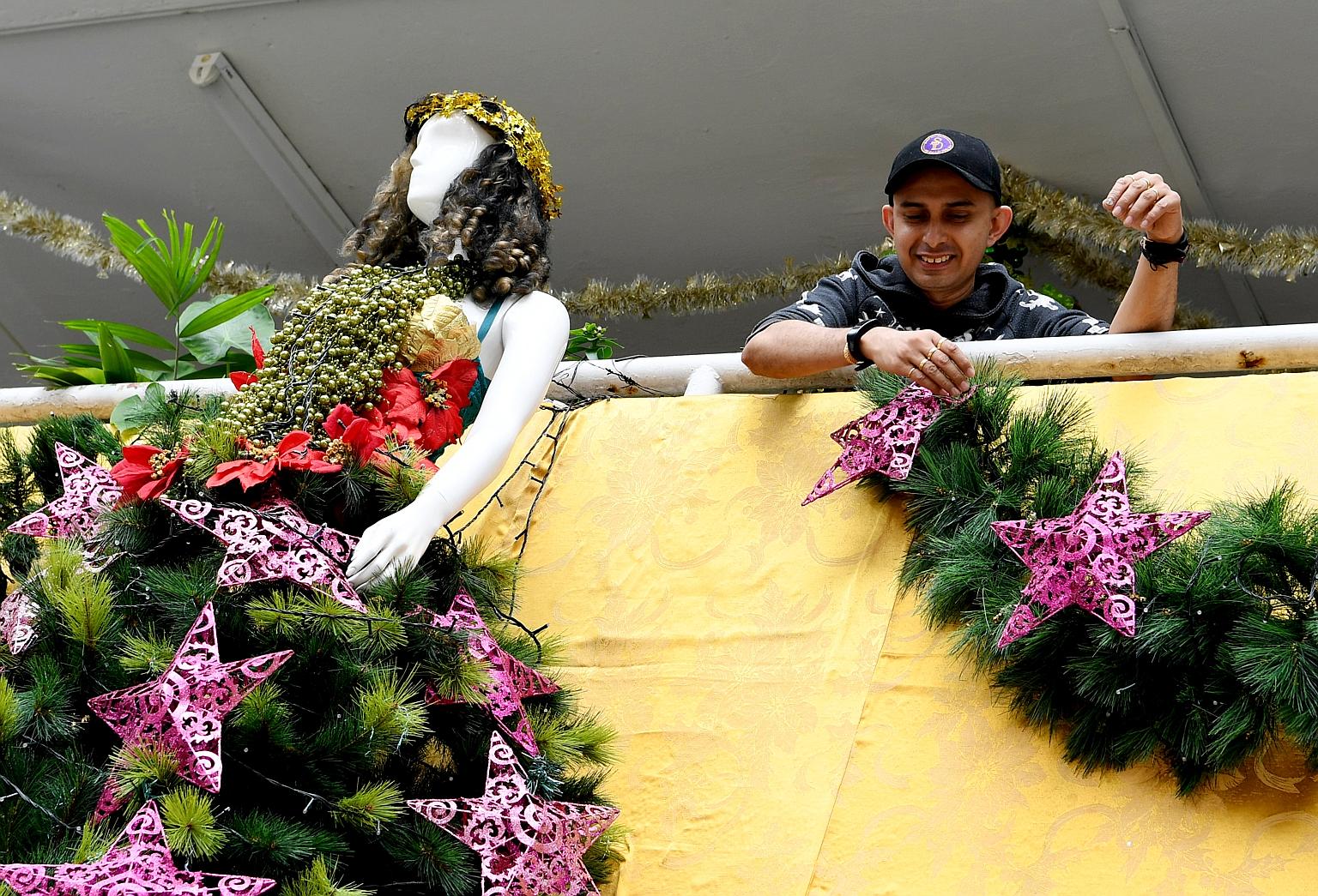 Mr Philip Sobrielo Gene with the Christmas decorations outside his mother's flat in Clementi. He managed to convince the town council that the decorations were safely fastened, so they will get to stay till the year end.