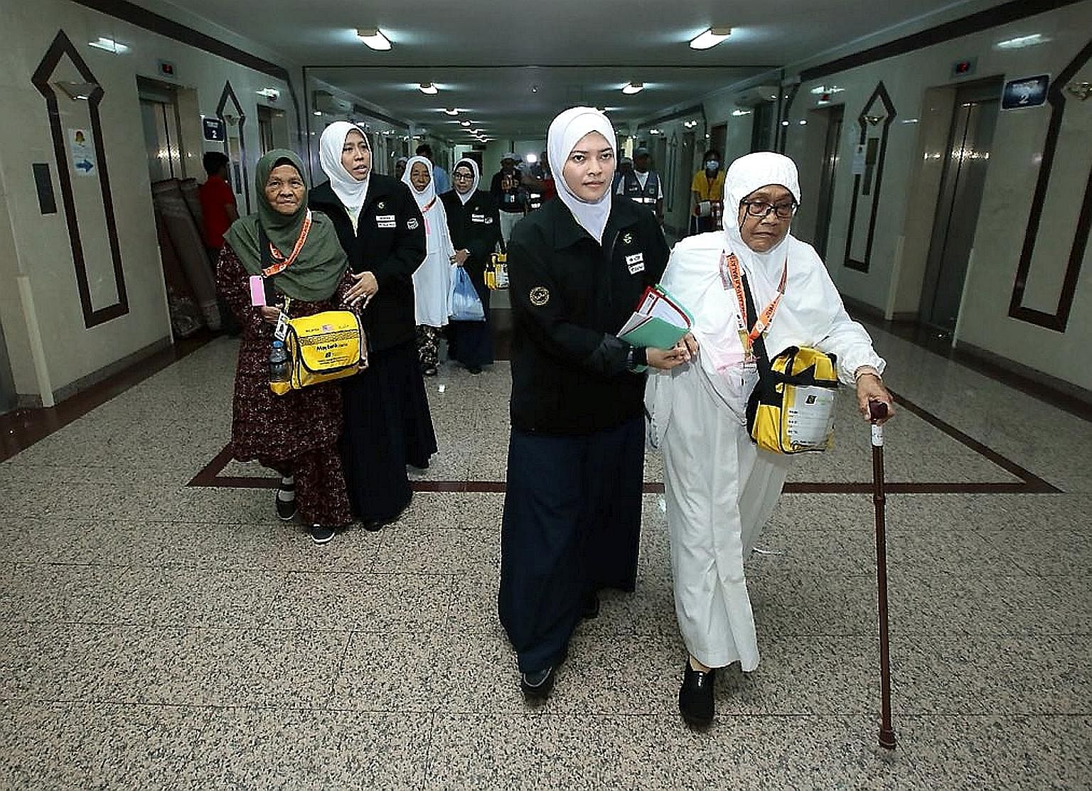 Elderly Malaysians being received by Tabung Haji staff (in black) on their arrival at a hotel in Mecca during the haj season in August. The government is taking over assets TH bought for nearly RM20 billion that are now worth RM9 billion less.