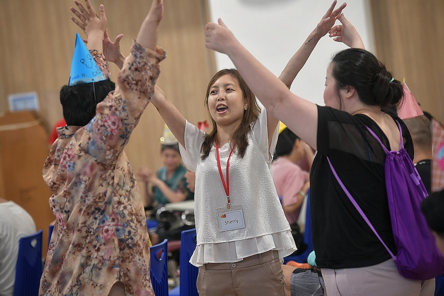 Ms Sherry Soon (centre), founder of Be Kind SG, and another volunteer (at right) engaging residents of a home the group visits in fun and games. Be Kind SG offers micro volunteering opportunities where people can pick and choose the activities they w