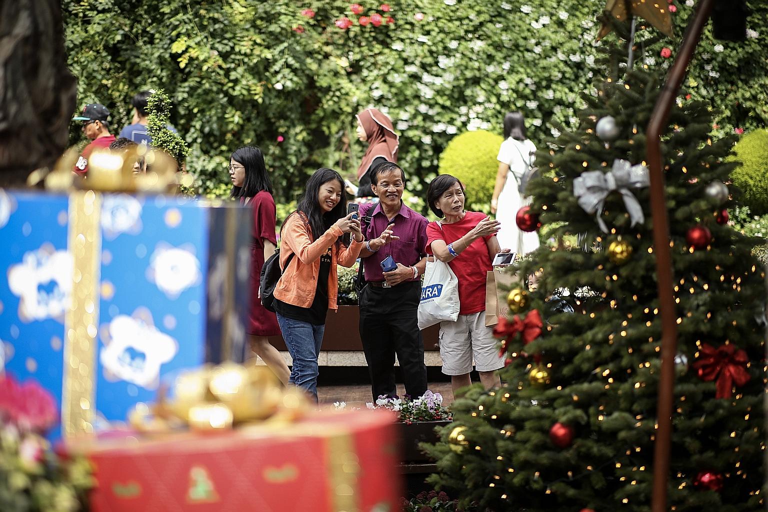 Mr Fok Hup Seng, a hospital cleaner, touring the Christmas display at the Flower Dome in Gardens by the Bay yesterday with his daughter Xin Yi and sister Hup Yee, 66, a retiree. They were among 350 lower-income union members and their families at an