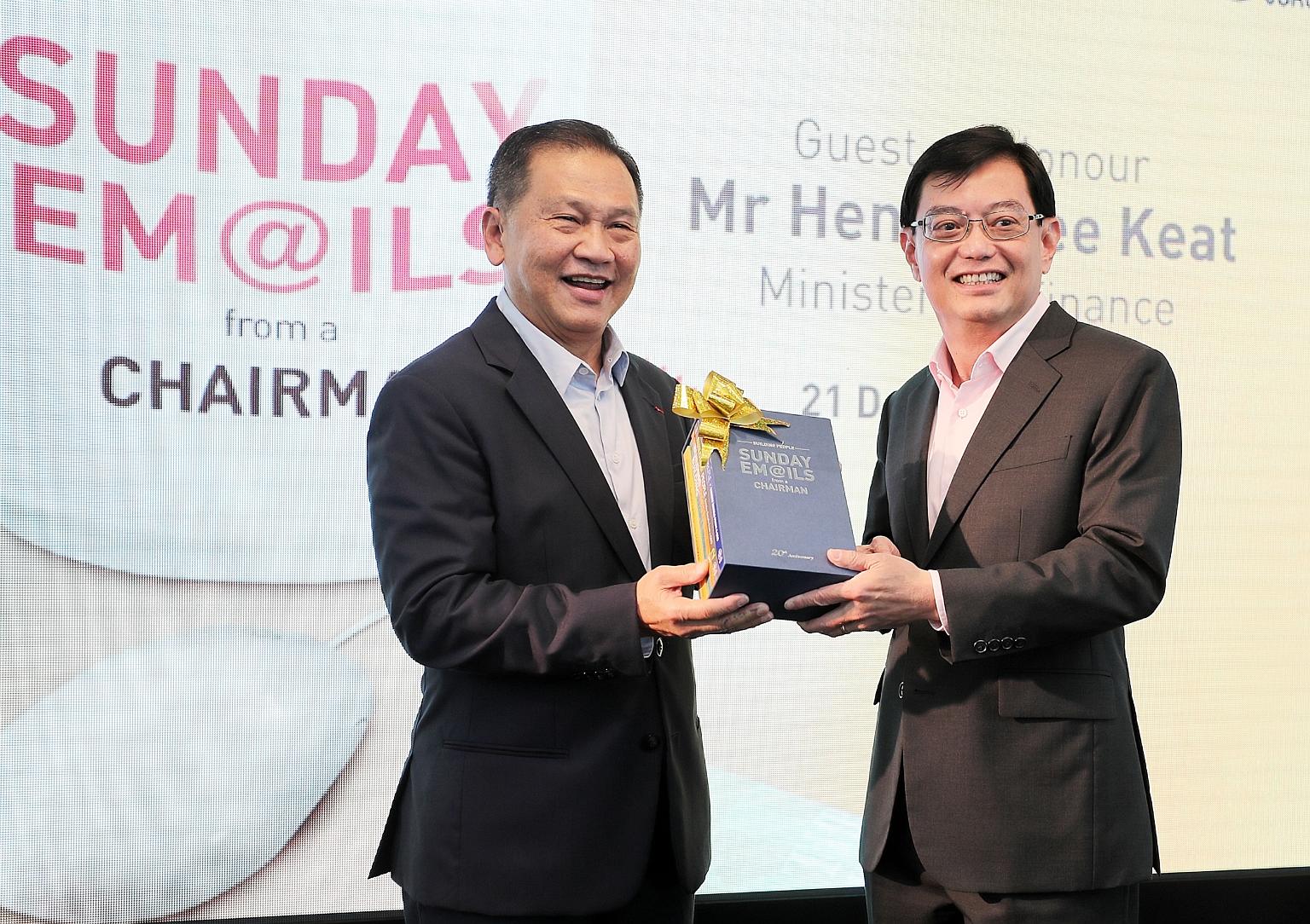 Mr Liew Mun Leong (left), chairman of Changi Airport Group and Surbana Jurong, presenting a box set of his books to Finance Minister Heng Swee Keat after the book launch at the National Library yesterday.