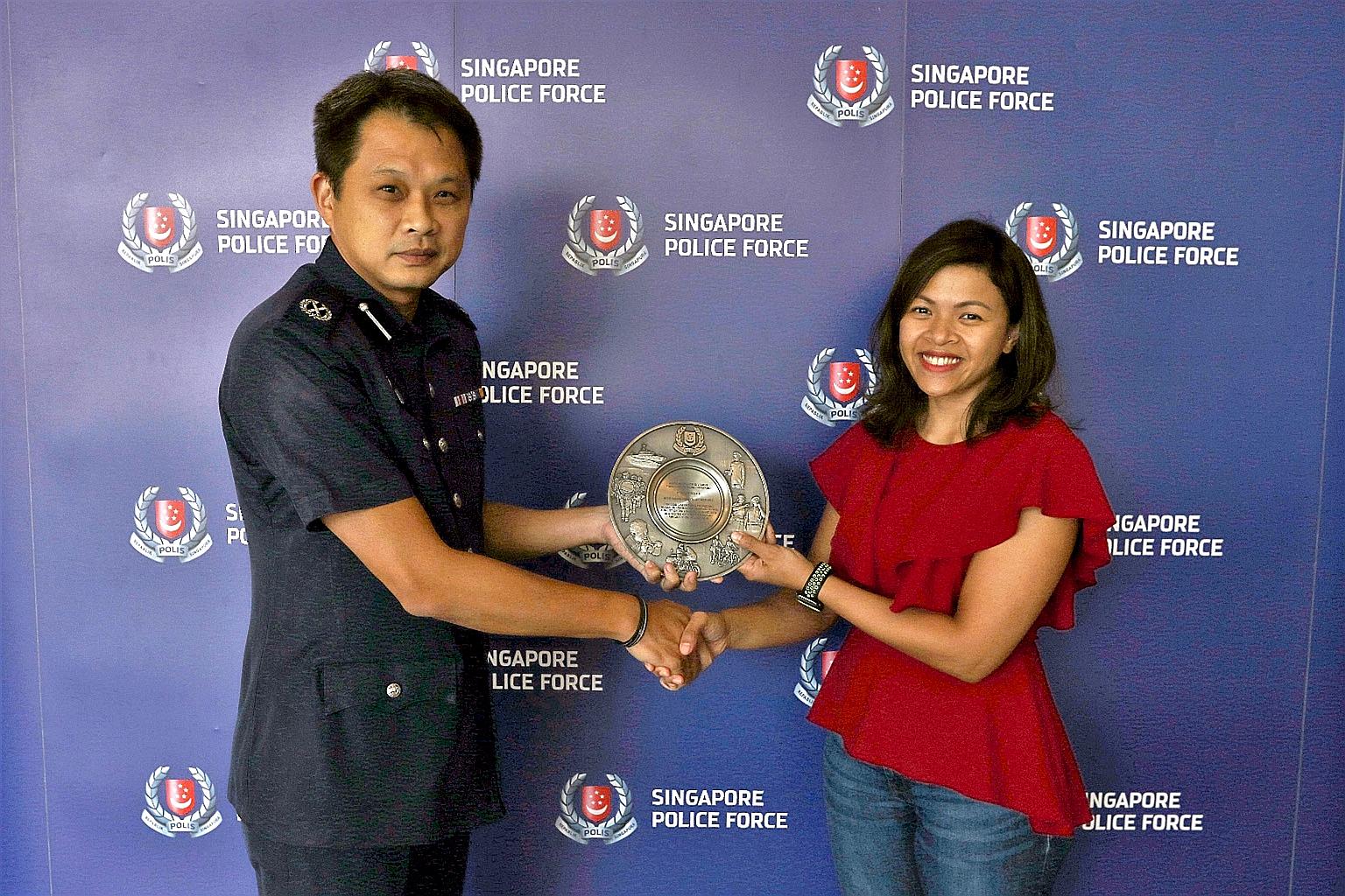 Deputy Commander of Airport Police Division Goh Wee Khern presenting the Public Spiritedness Award to Ms Kanya yesterday.
