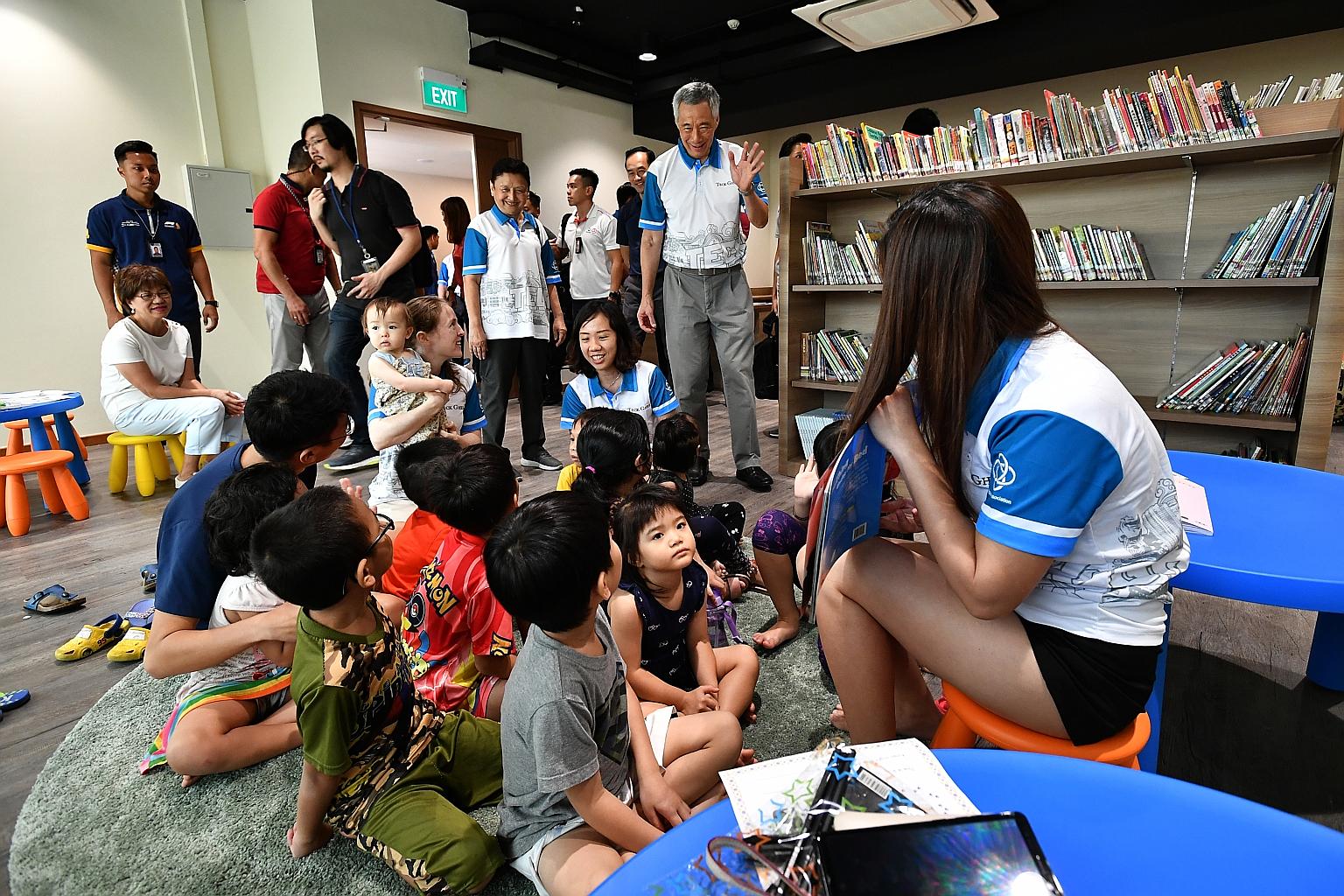 Prime Minister Lee Hsien Loong greeting children and residents taking part in a KidsRead programme at a mini library in Teck Ghee Community Club yesterday. The upgraded CC in Ang Mo Kio reopened in August last year, two years after it closed for reno