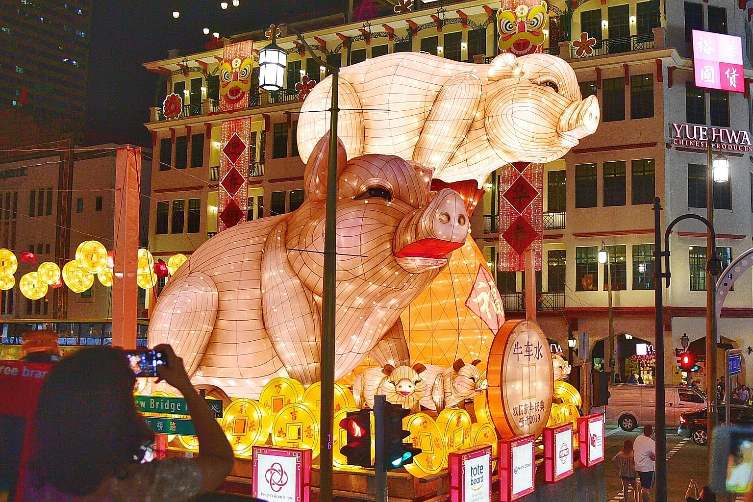 The centrepiece of this year's Chinese New Year display in Chinatown features pigs perched on top of a lantern depicting a bulging purse overflowing with gold coins.