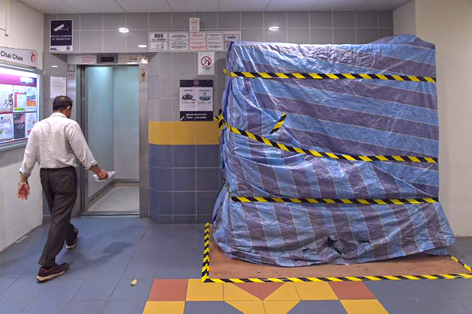 The cordoned-off lift at Block 805 Chai Chee Road where a worker died during upgrading works on Monday. MOM is investigating the incident.