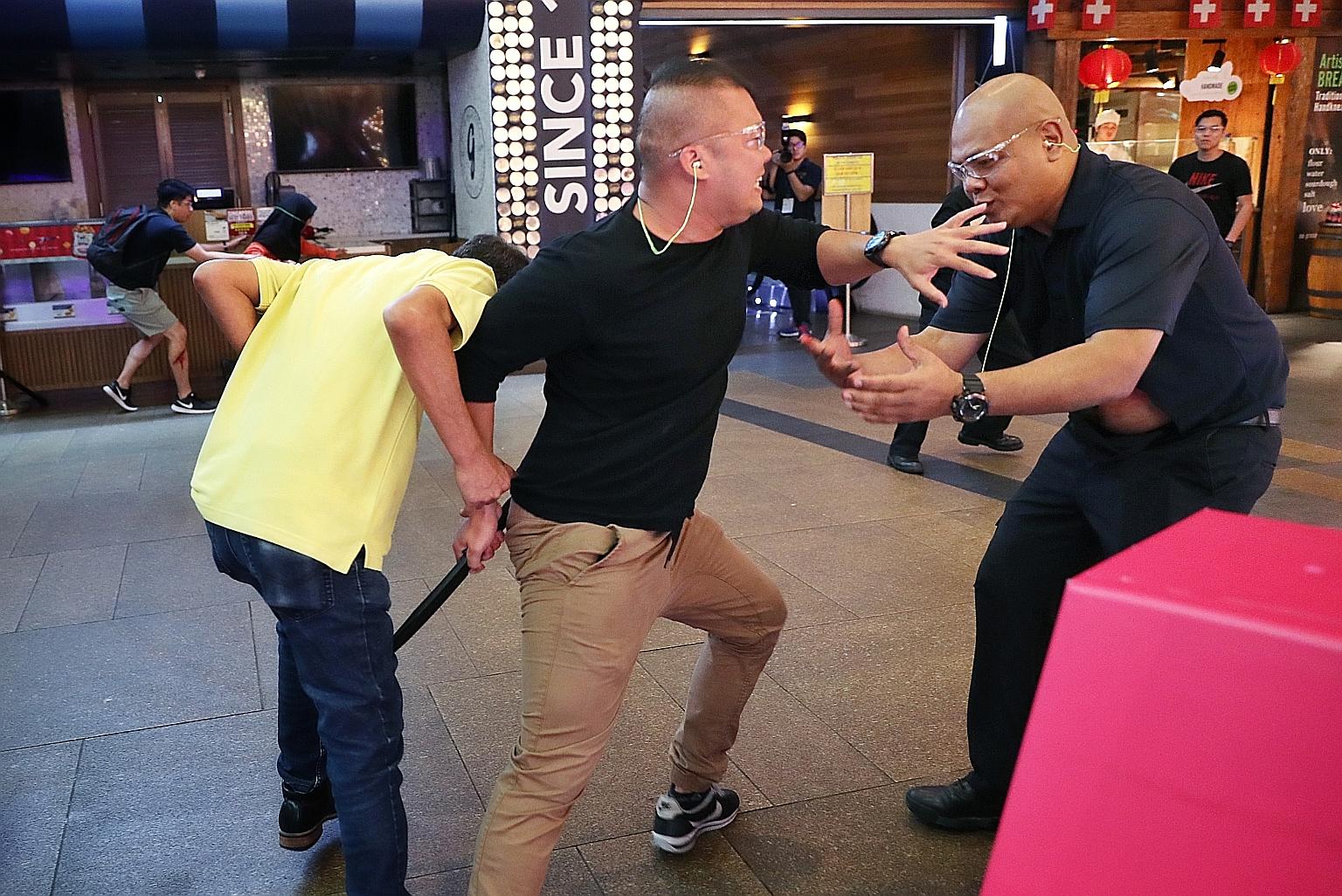 From above: An "attacker" (centre) trying to "stab" someone during Exercise Heartbeat at 313@Somerset yesterday; members of the Singapore Police Force's Ground Response Force responding to the attack; and Singapore Civil Defence Force officers attend