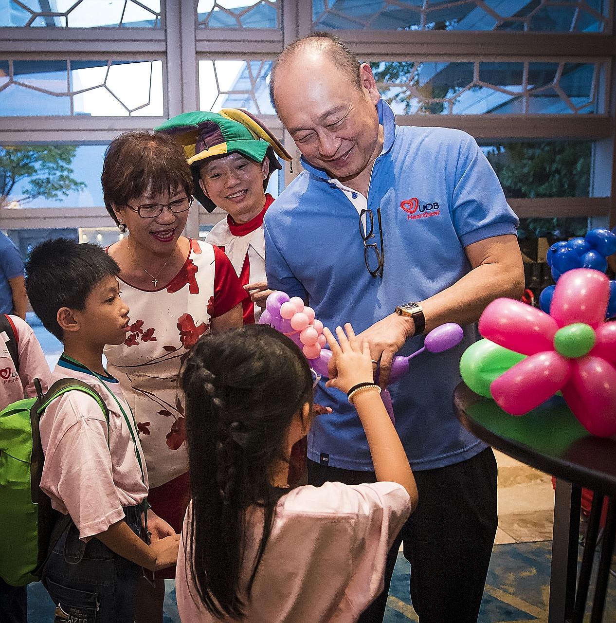 Mr Wee Ee Cheong, deputy chairman and chief executive of the United Overseas Bank (UOB), and Ms Denise Phua, Mayor of the Central Singapore District, giving out sculpted balloons to children residing in Kampong Glam. UOB and the Central Singapore Com