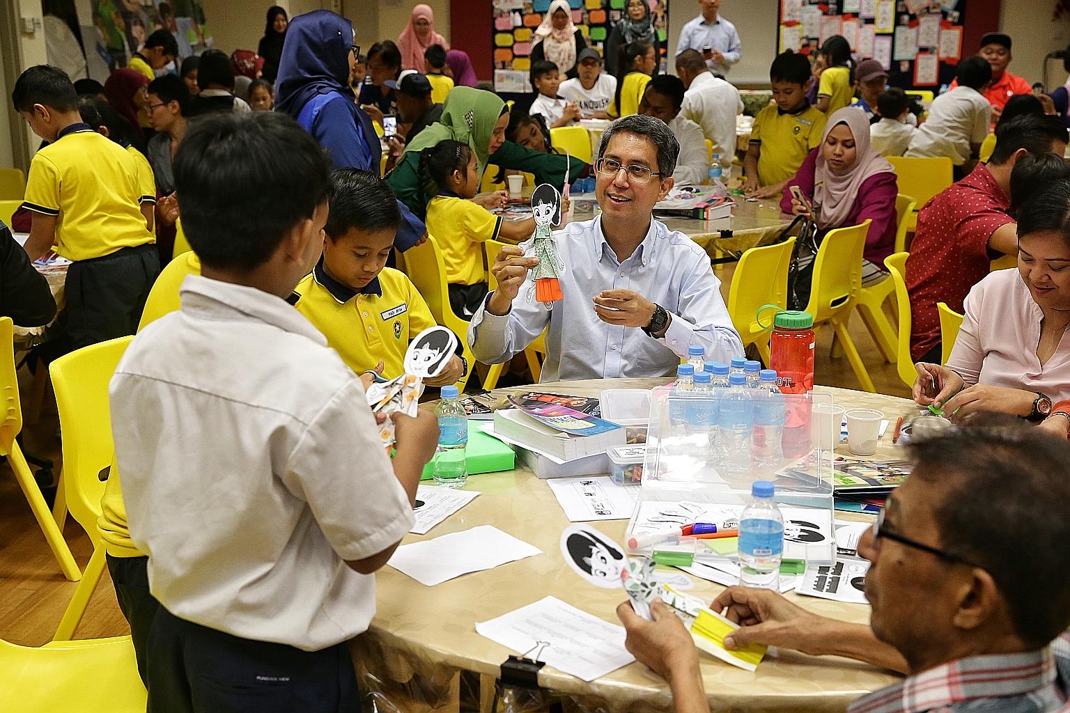 Senior Parliamentary Secretary for Education Muhammad Faishal Ibrahim joining pupils and parents in a Storygami activity during a workshop on reading using the Nabil Nabilah Reader Series, at Punggol View Primary School yesterday.