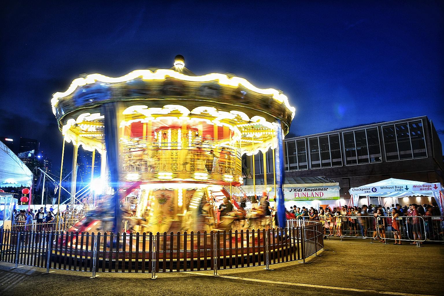 Children from underprivileged families enjoy a swirling ride on what is believed to be the first double-storey carousel in Singapore at the annual River Hongbao festival. Games and ride provider JKids Amusement sponsored $30,000 worth of games cards 