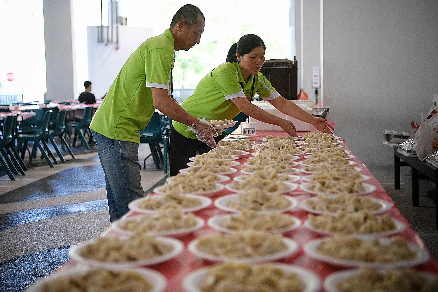 Chinese migrant worker Wang Yong (left) and fellow Chinese national Dai Yan Zhao, 47, preparing to serve traditional dumplings for over 150 attendees at a Chinese New Year party yesterday.