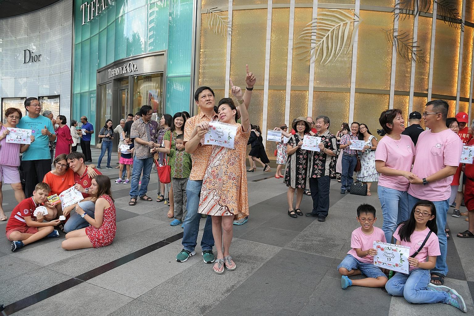Married couples, some with their children, participating in a "freeze flash mob" - posing still for five minutes - to celebrate World Marriage Day outside ION Orchard yesterday. A total of 280 people took part in the event. To mark their wedded bliss