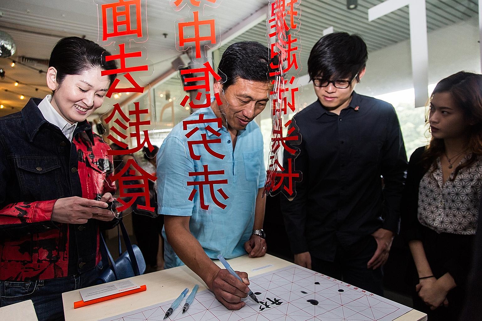 Education Minister Ong Ye Kung writing a message of well wishes for The Future of Our Pasts at the launch of the festival at Golden Mile Tower's The Projector yesterday. Looking on are (from left) Mr Gene Tan, executive director of the Singapore Bice